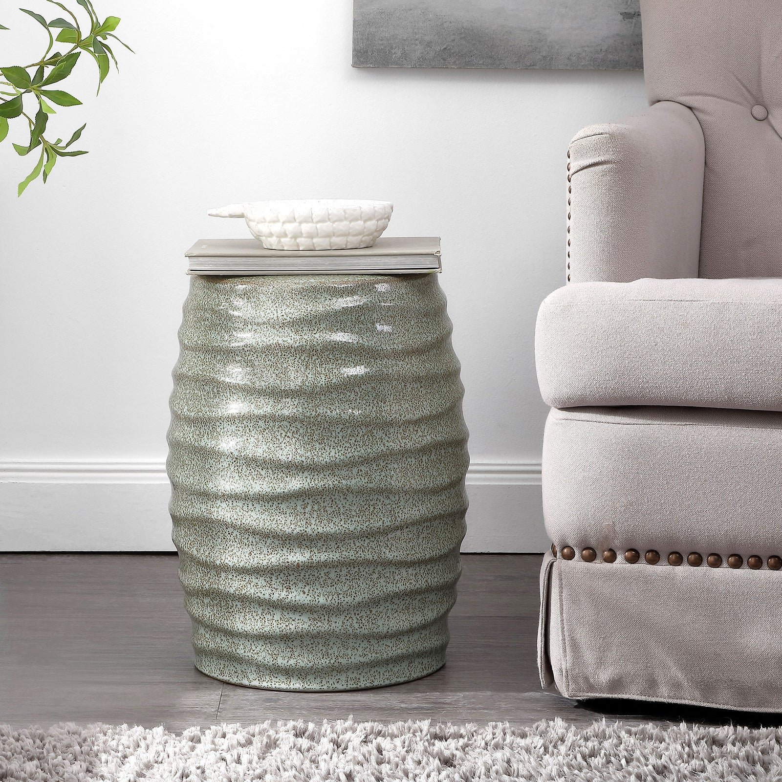Speckled blue-gray ceramic stool serves as a compact side table beside an upholstered armchair. || ACS4575B || front_room