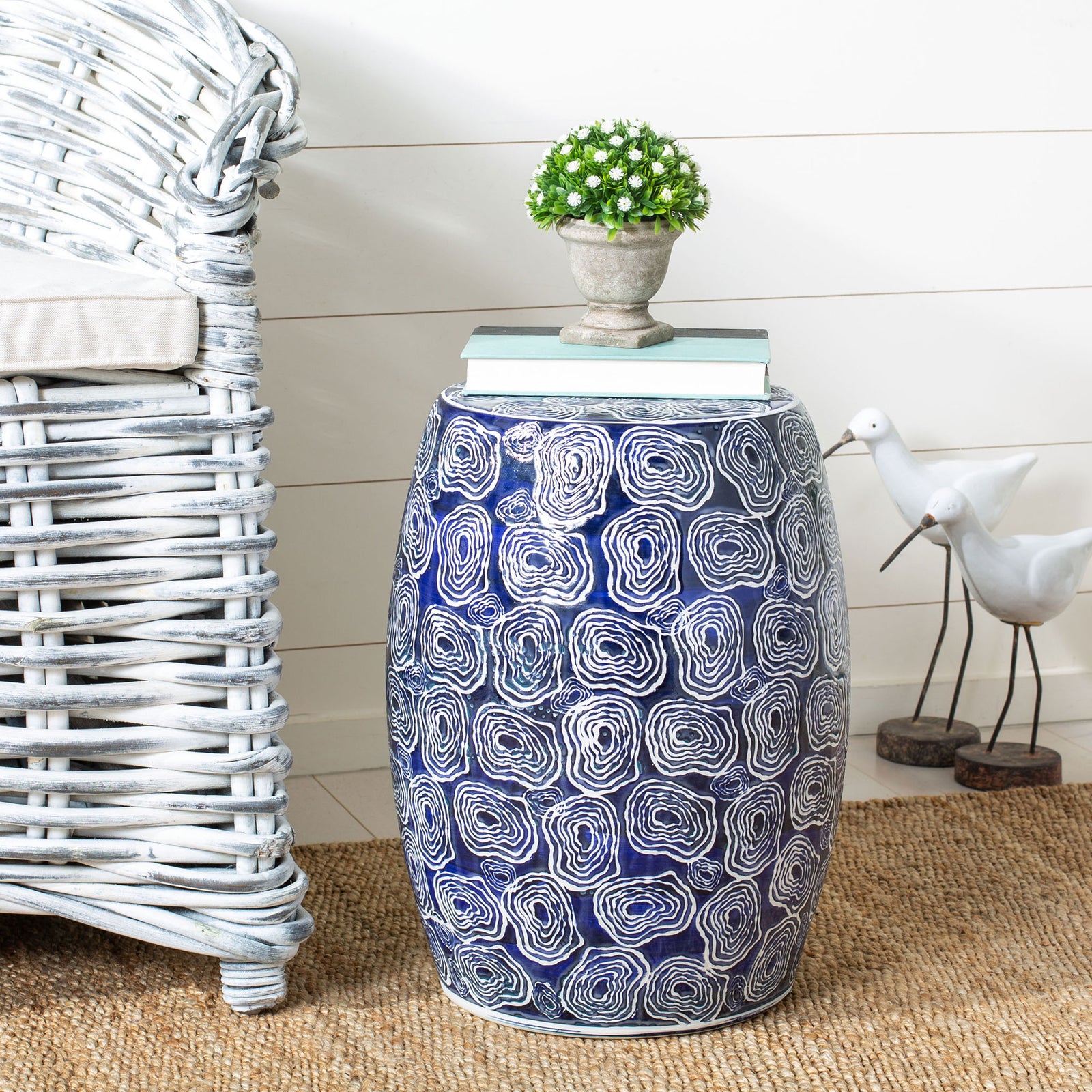 Blue and white ceramic garden stool doubles as a side table for books and a potted plant || ACS4580A || front_room