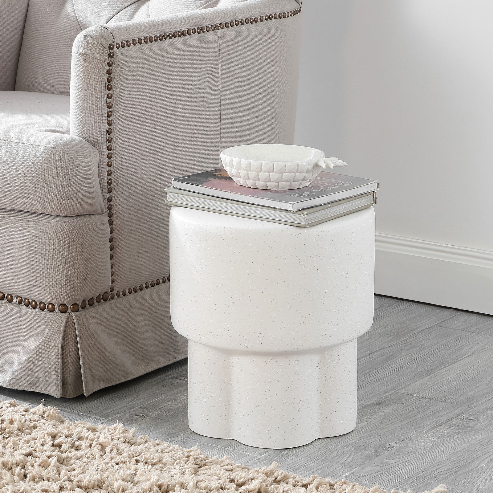 White speckled ceramic stool serves as a compact side table for books and decor || ACS4593B || front_room