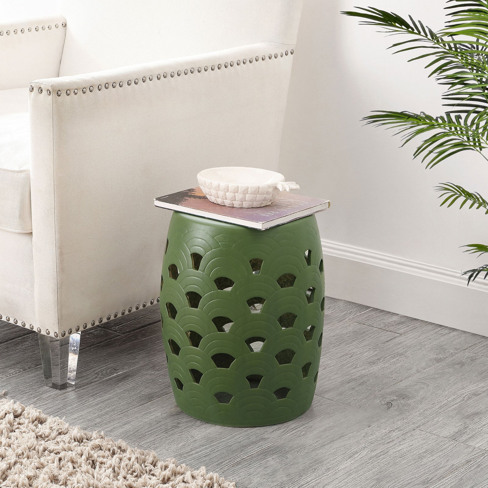 Moss green openwork stool adds color beside an upholstered chair while serving as a side table. || ACS4597B || front_room