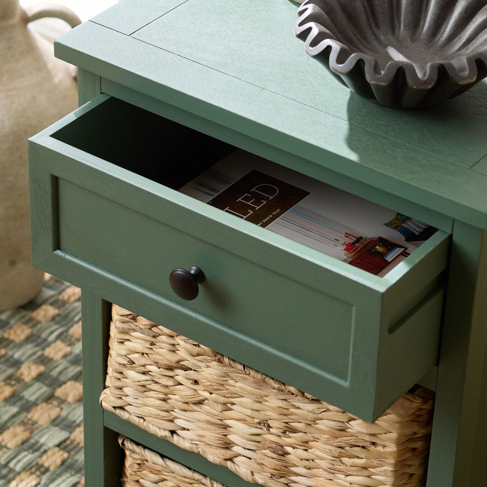 An open dusty green drawer stores small essentials above the woven basket compartments. || AMH5700L || storage_open_room