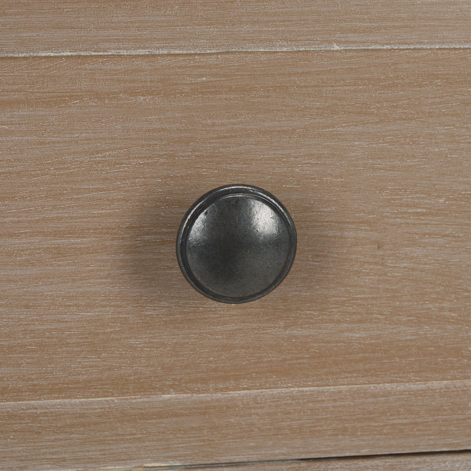 A round dark metal knob contrasts with the softly washed wood drawer front. || AMH5743E || handle_studio