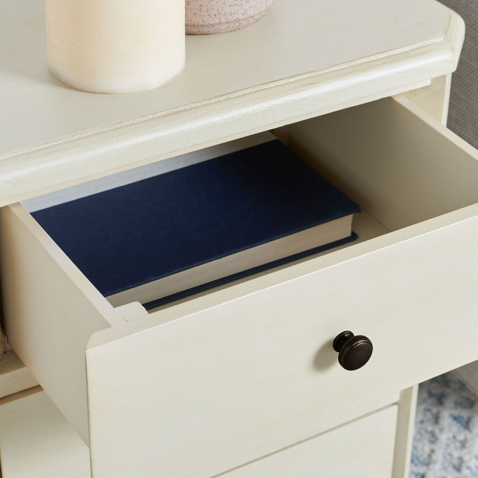 A dark bronze knob fronts an open barley drawer that keeps a favorite book within easy reach. || AMH6629D || storage_open_room