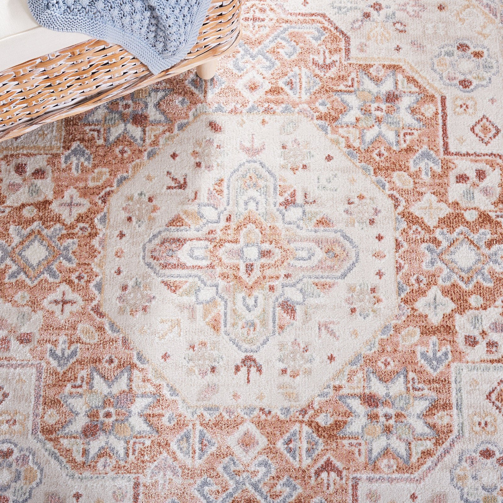 Ornate central medallion and border motifs in beige, rust, and pale blue for a timeworn look. || BLR202B-5 || detail_room
