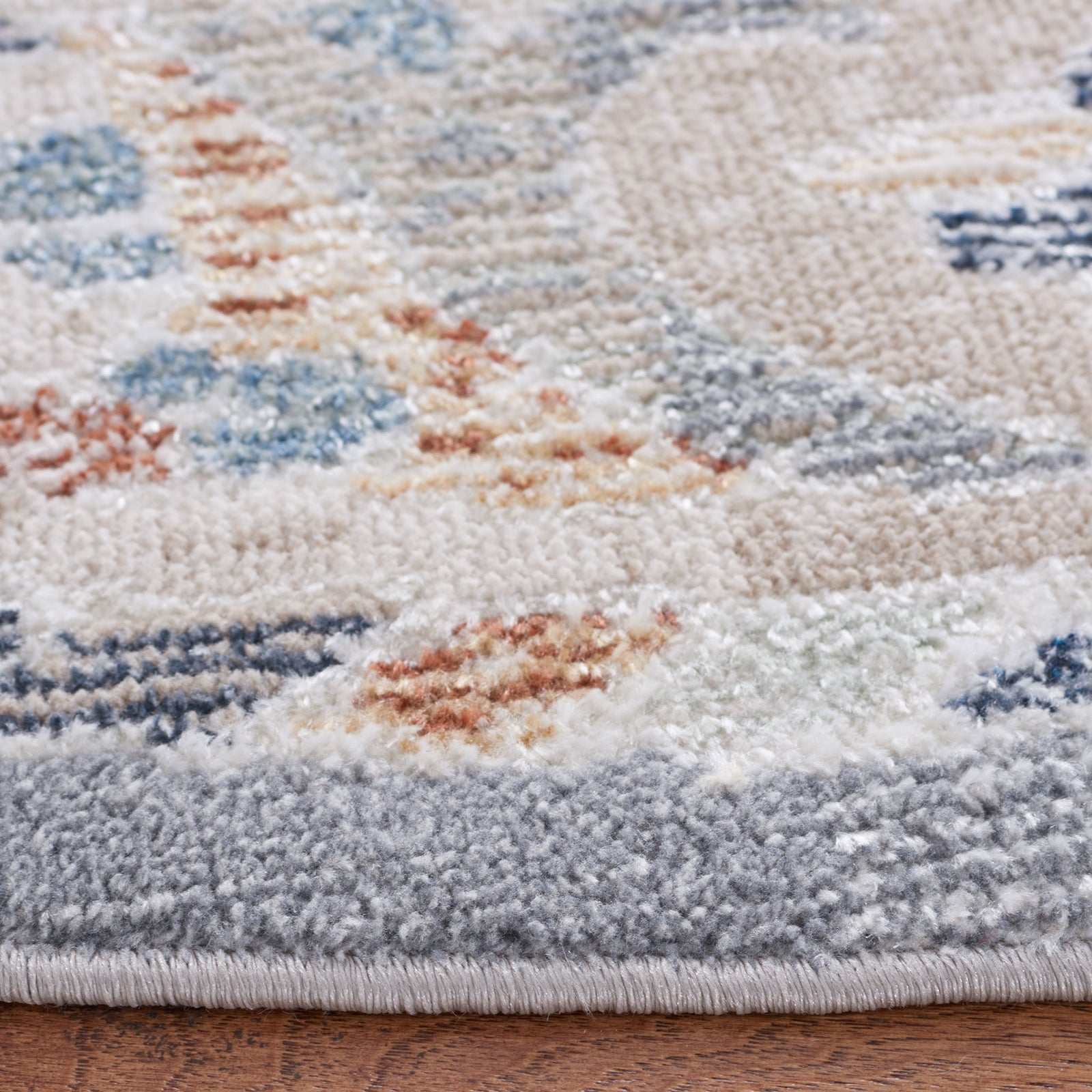 Low-pile texture and neatly serged edge in soft beige and blue tones for a refined finish. || BLR212B-7R || detail_room