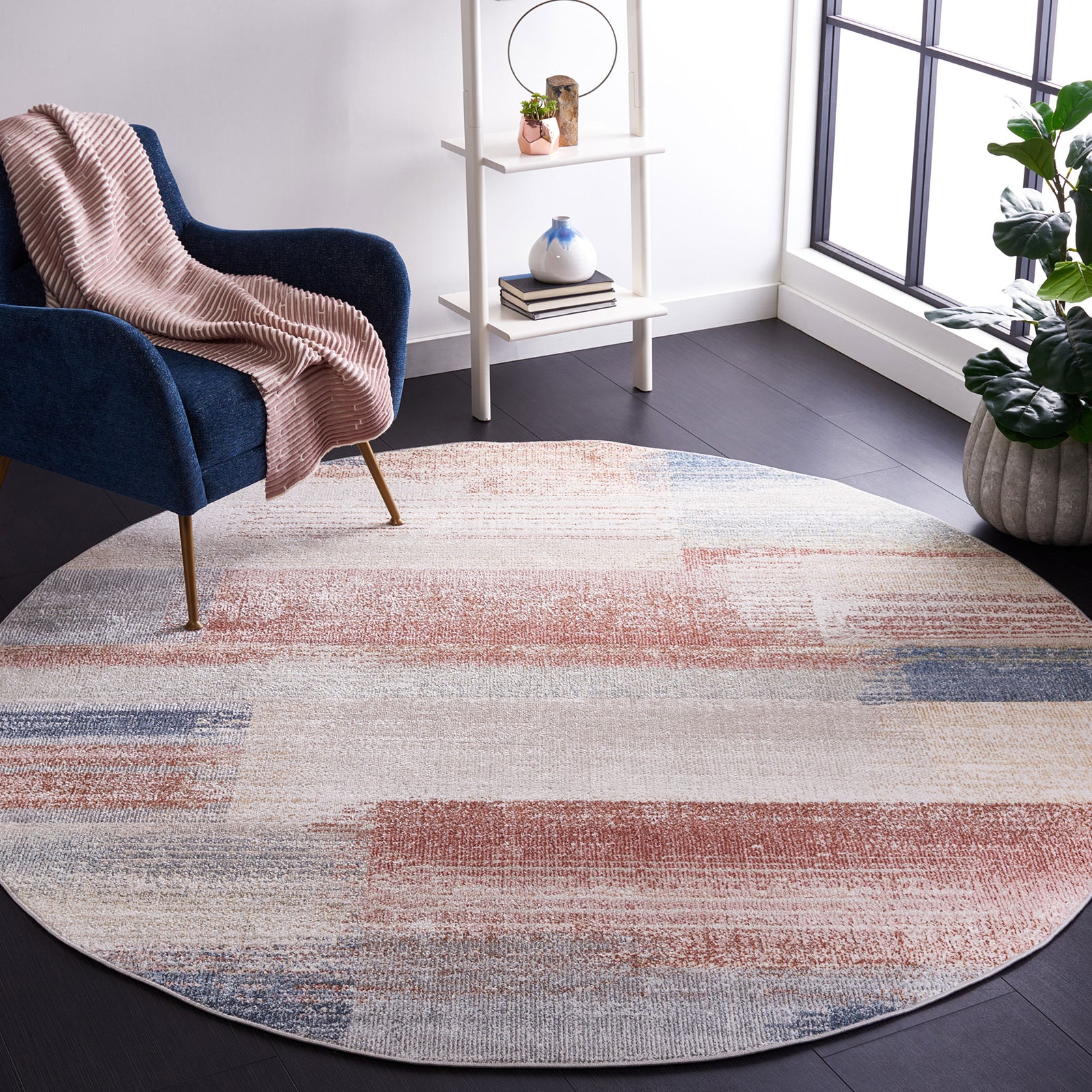 Modern round rug in beige, rust, and blue adds an artistic touch to a bright, cozy living space || BLR216B-7R || front_angle_room