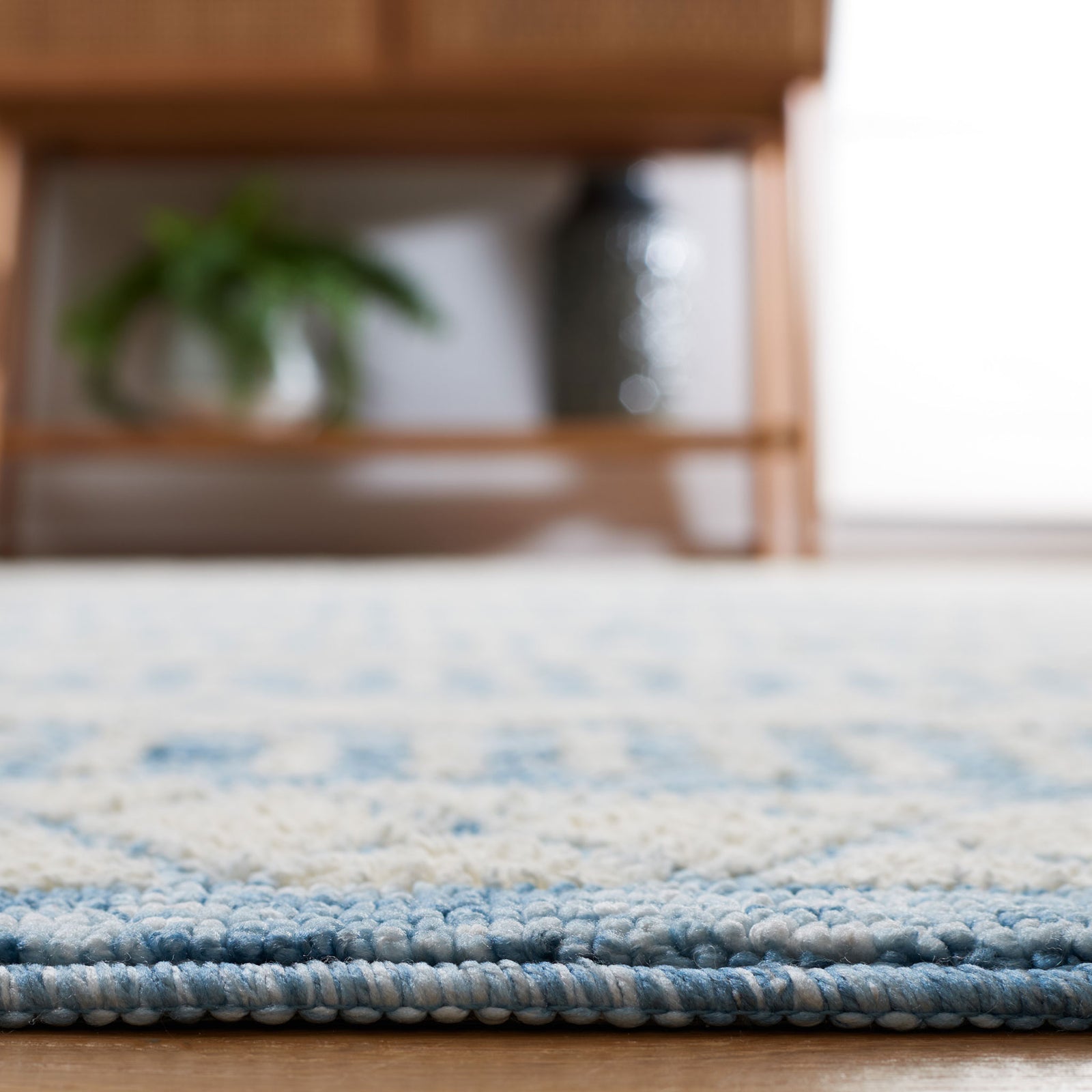 Soft pile and smooth edge binding in ivory and blue showcase the rug's refined finish || ECR114A-5 || detail_room