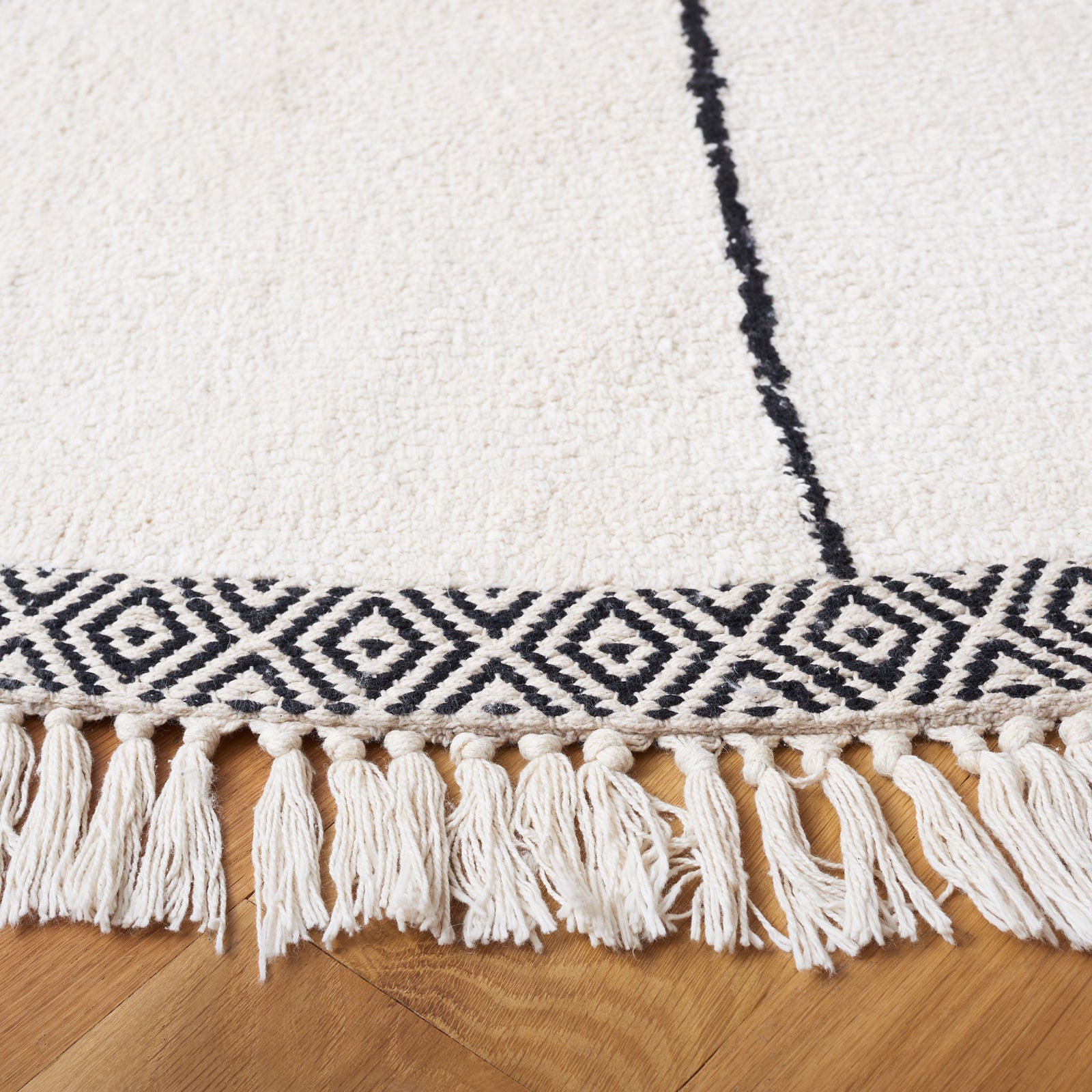 Ivory round rug with black diamond border and tassel fringe for a crisp, modern look || ECR210A-6R || detail_room
