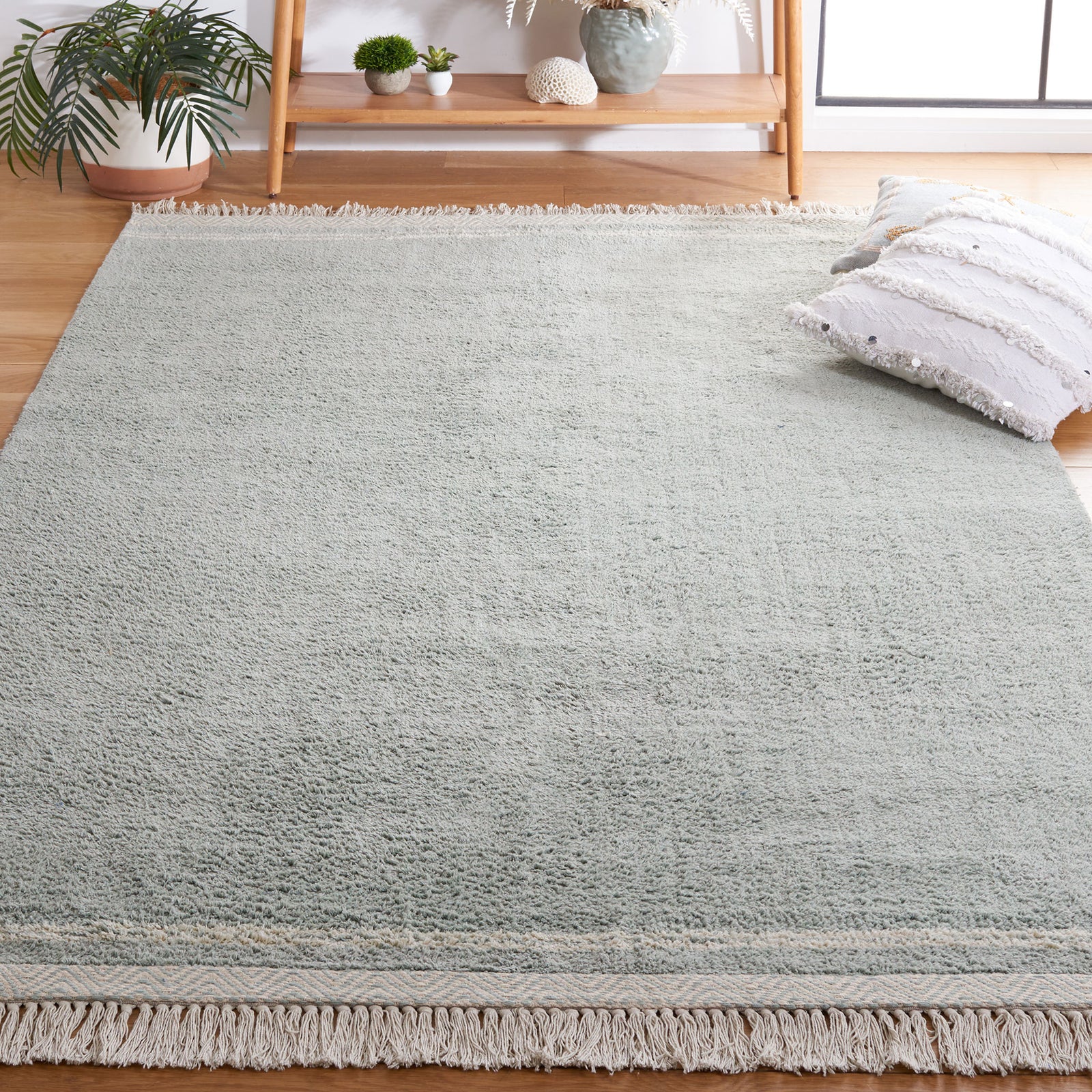 Versatile light blue area rug with ivory tassels and a subtle border suits airy modern spaces || ECR211J-5 || front_angle_room