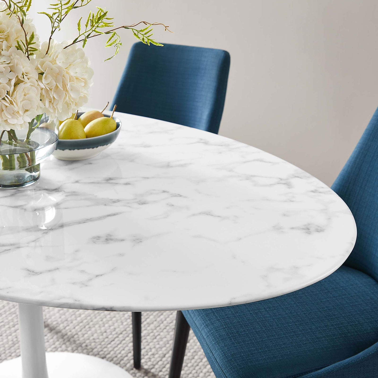 Polished faux marble surface reflects light beautifully beside blue upholstered dining chairs || EEI-1135-WHI || detail_room