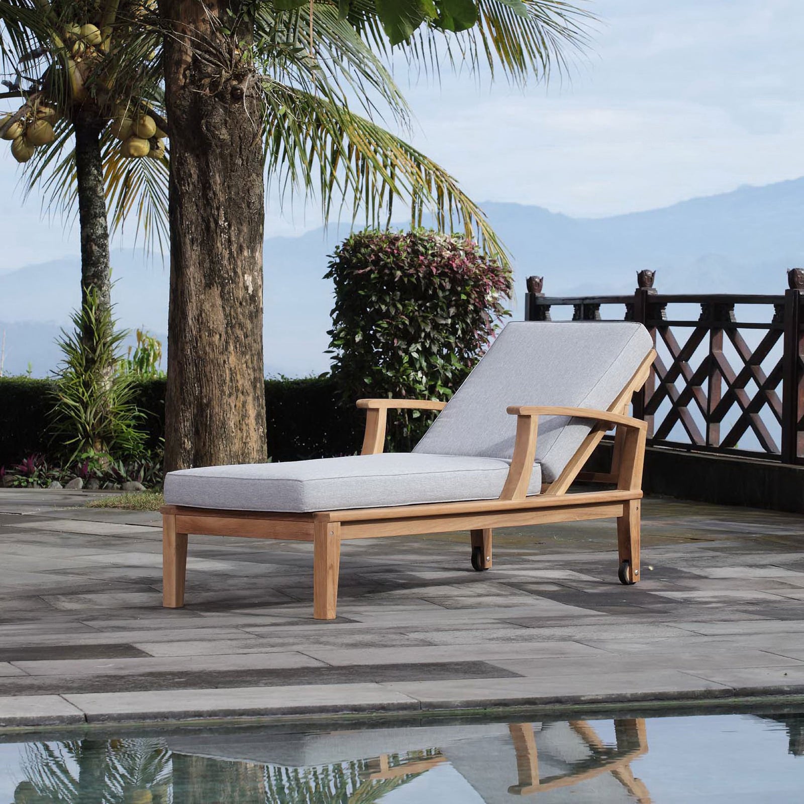 Teak chaise lounge with gray cushions styled by a poolside patio for relaxed outdoor lounging || EEI-1151-NAT-GRY-SET || front_angle_room