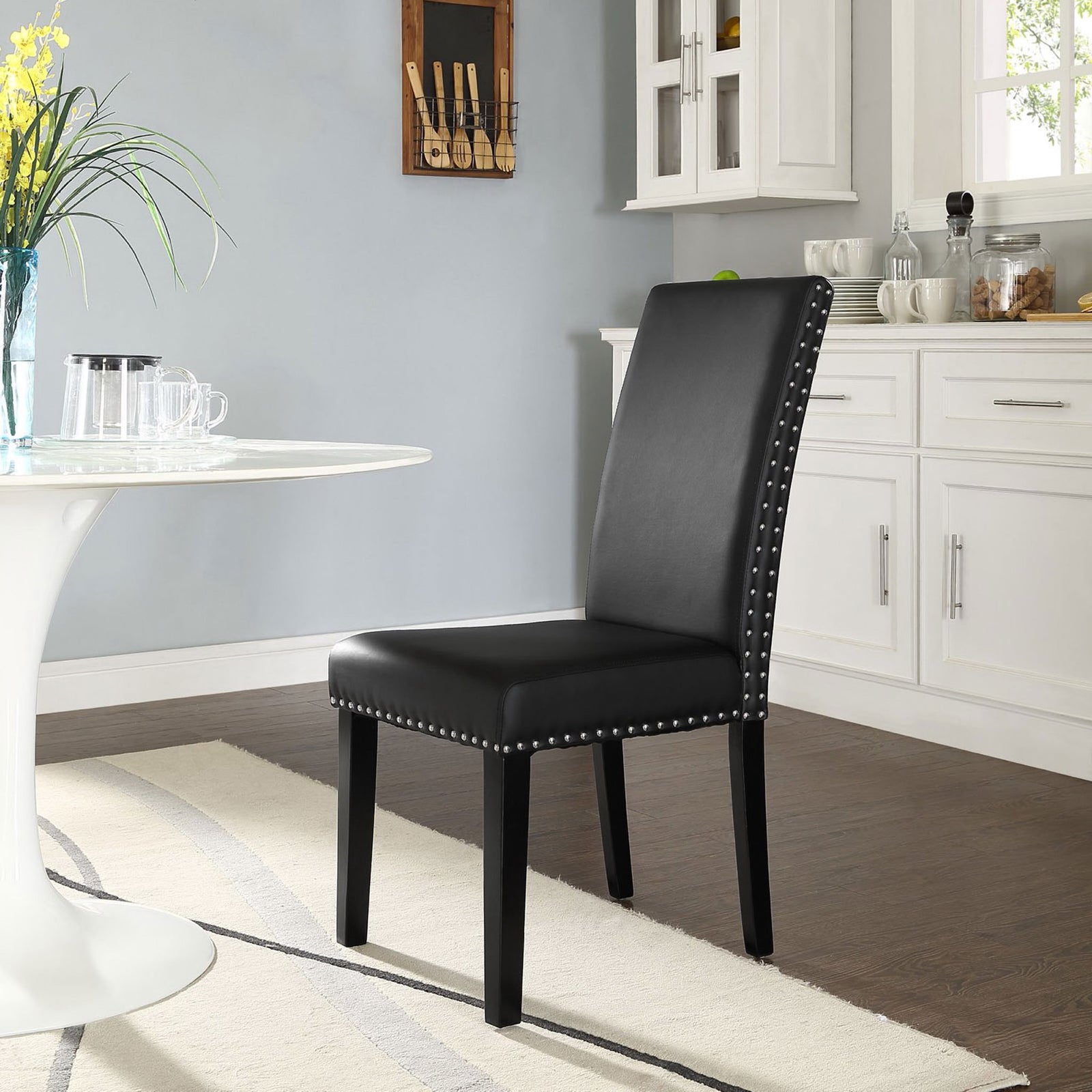 Black faux leather dining chair bringing modern elegance to a bright kitchen setting || EEI-1491-BLK || front_angle_room