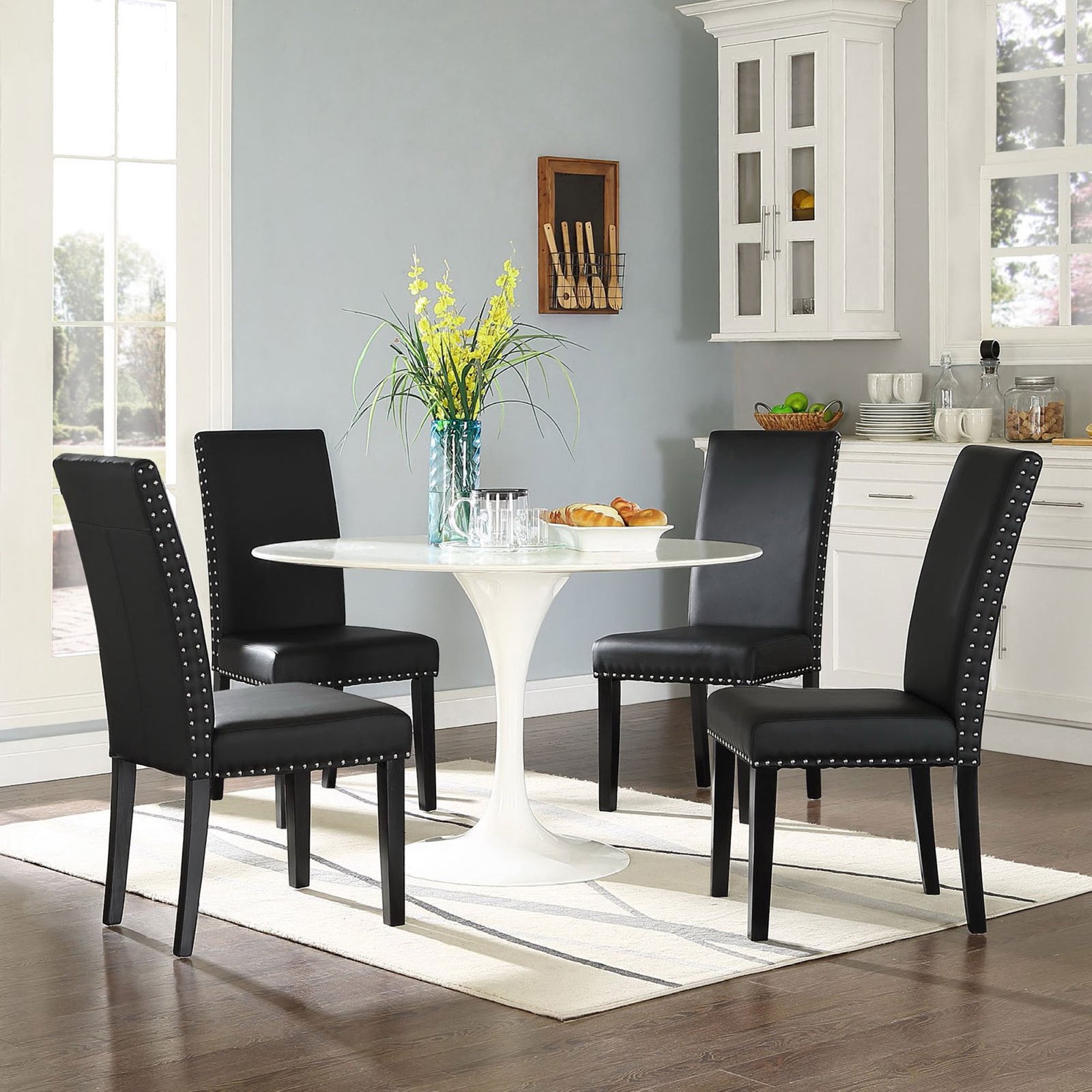 Set of black faux leather dining chairs surrounding a round white table in a cozy breakfast nook || EEI-1491-BLK || front_angle_room