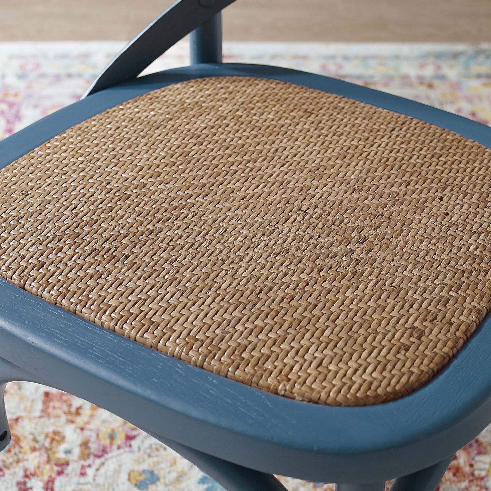 Woven natural rattan seat surface framed by smooth harbor blue wood in a dining room setting || EEI-1541-HAR || detail_room