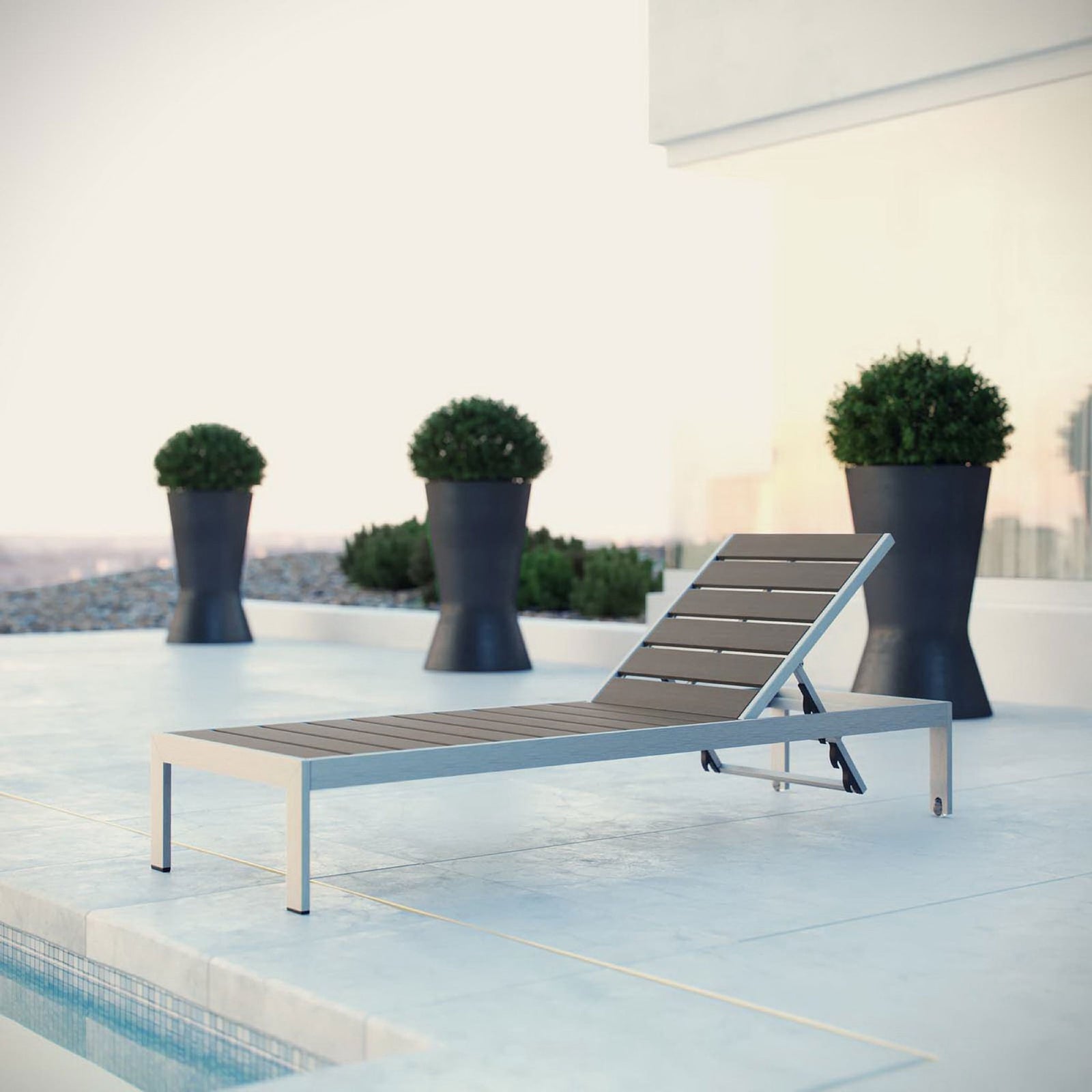 Gray slatted Shore chaise beside a sleek pool terrace with sculpted planters || EEI-2247-SLV-GRY || front_angle_room