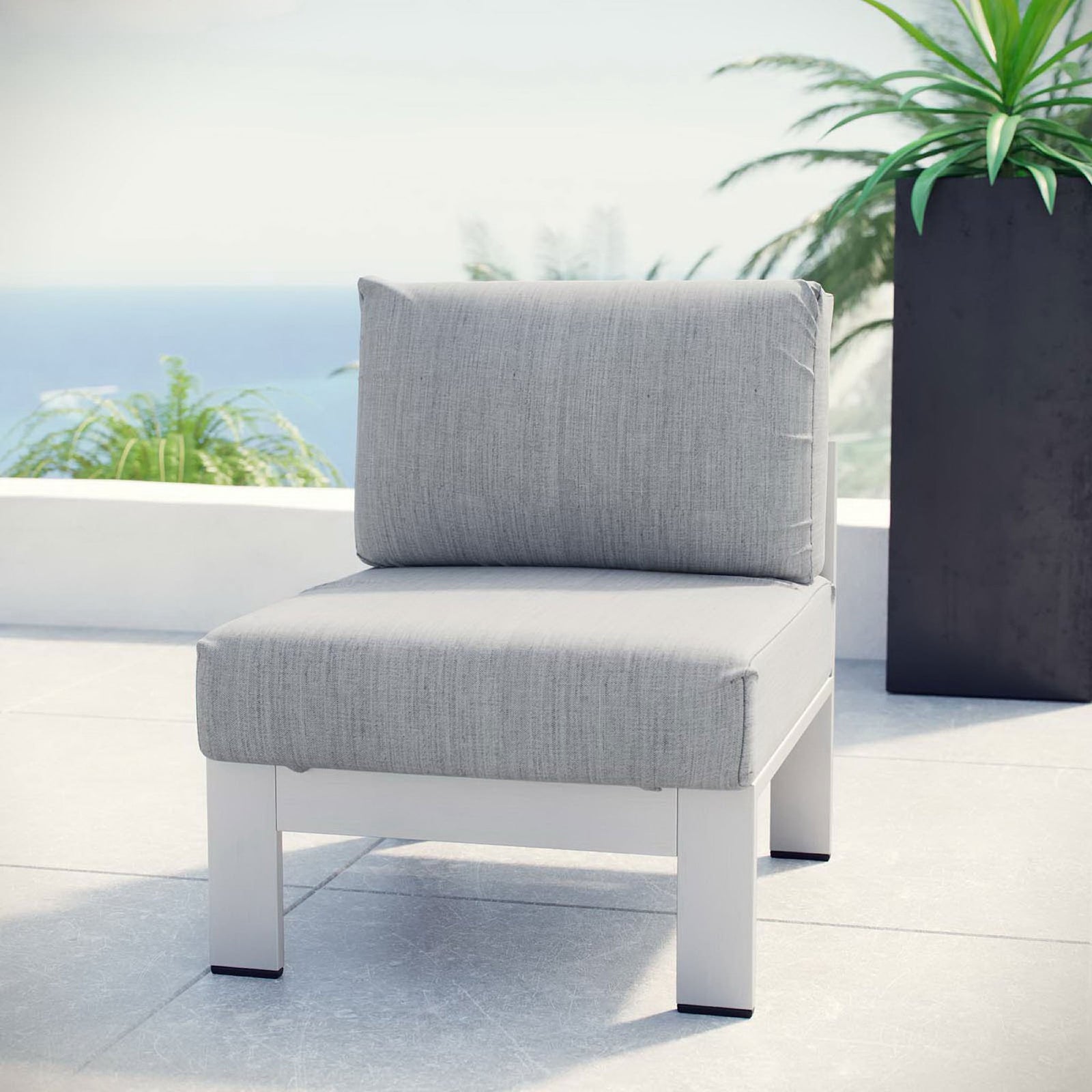 Silver gray armless outdoor chair brings clean, modern comfort to a sunny balcony || EEI-2263-SLV-GRY || front_angle_room