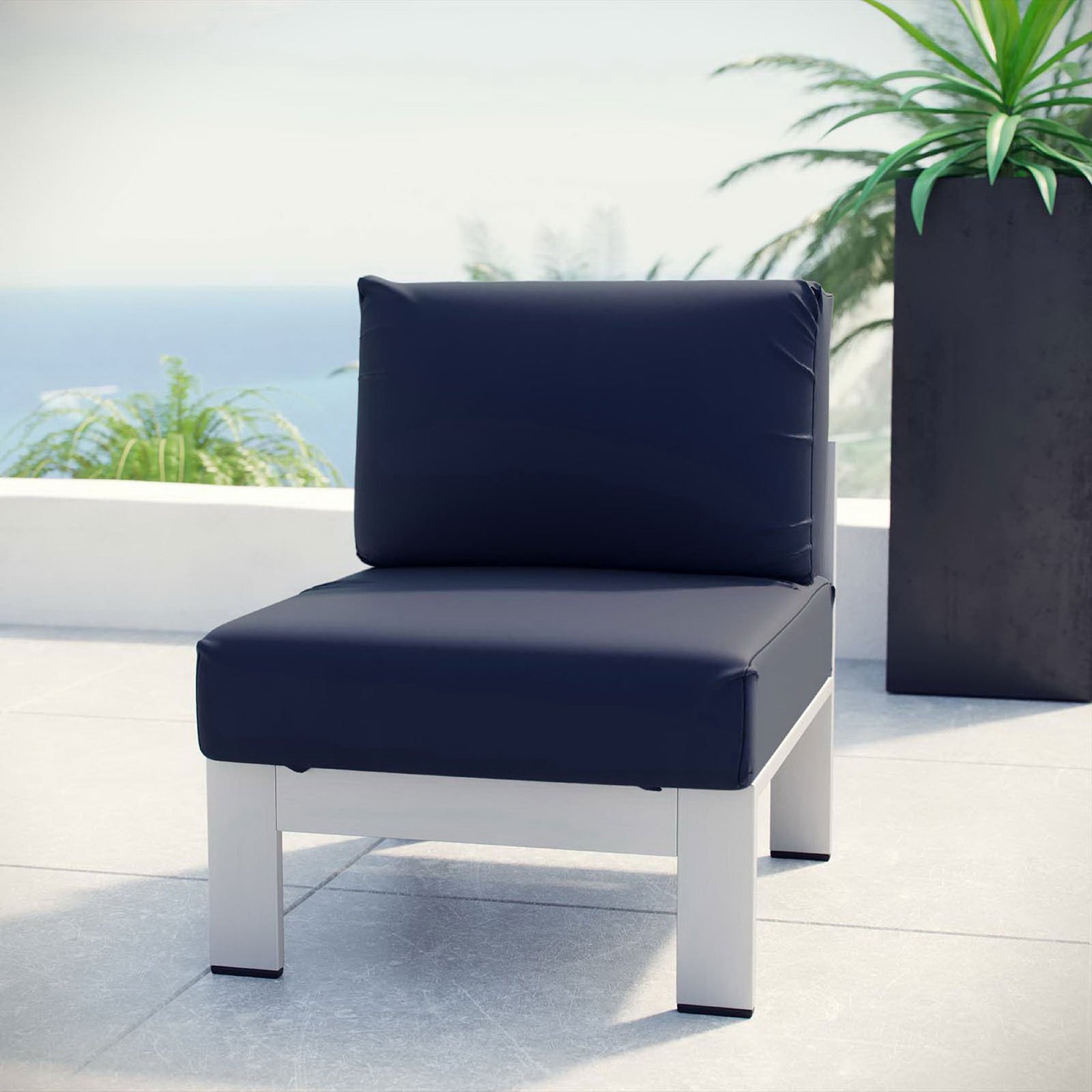 Navy armless outdoor chair anchors a modern balcony seating area with bold contrast || EEI-2263-SLV-NAV || front_angle_room