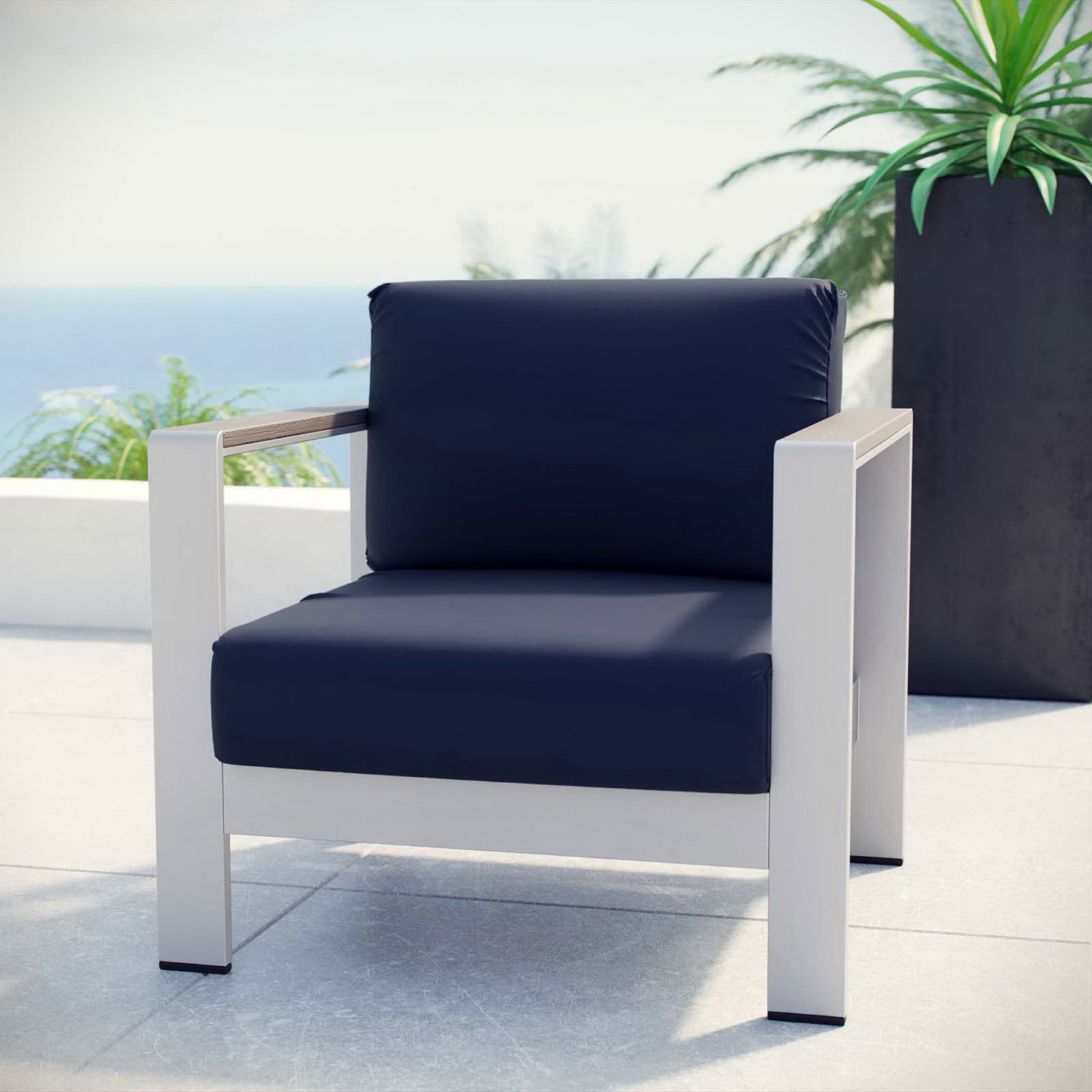 Navy cushioned outdoor armchair creates a chic lounge spot on the terrace or balcony || EEI-2266-SLV-NAV || front_angle_room