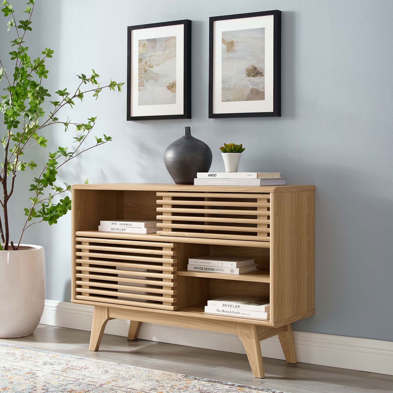 Render oak display stand used as a media console with stacked books and decorative vase || EEI-2542-OAK || front_angle_room
