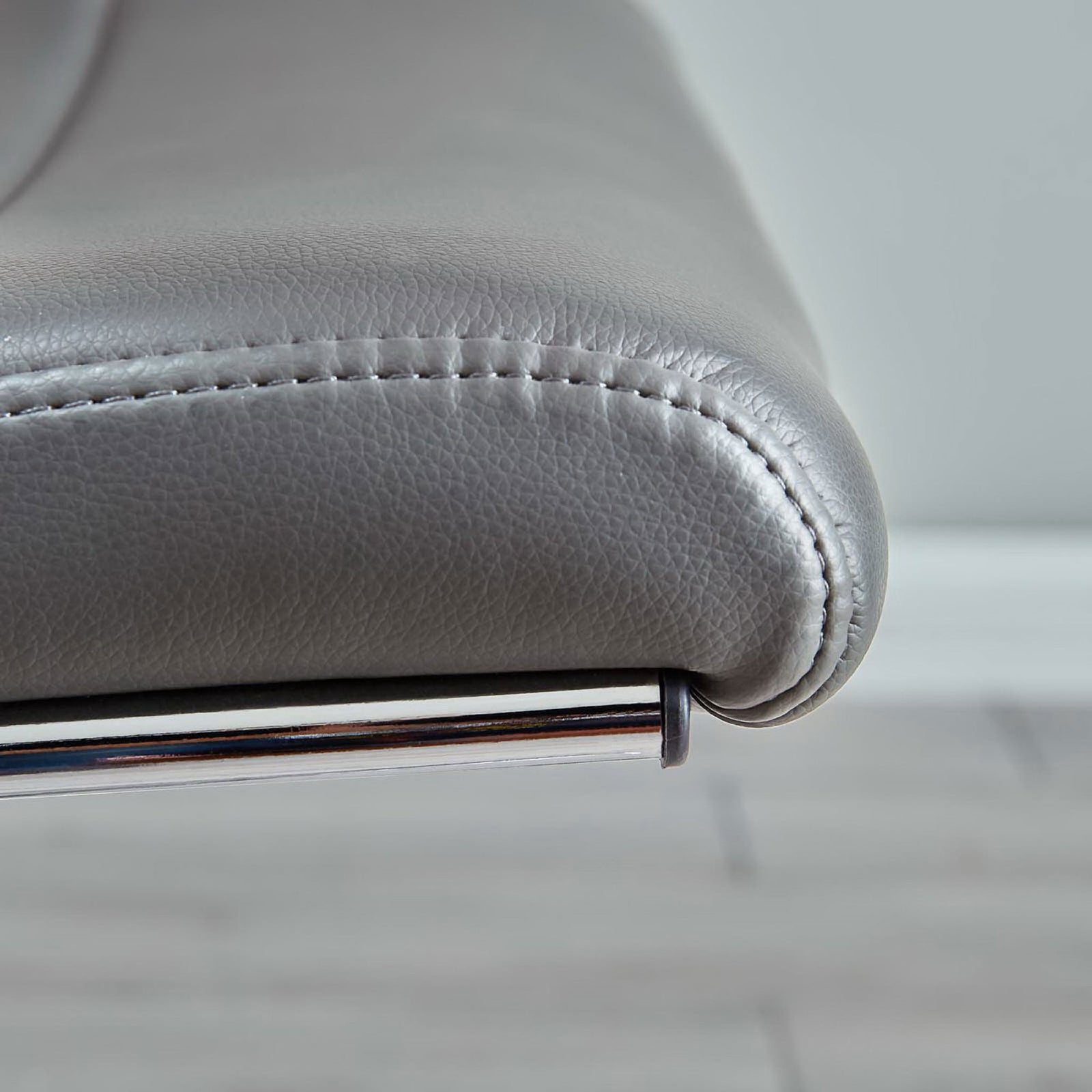 Detail of gray vinyl seat edge on office chair showcasing fine stitching and smooth upholstery texture. || EEI-273-GRY || detail_room