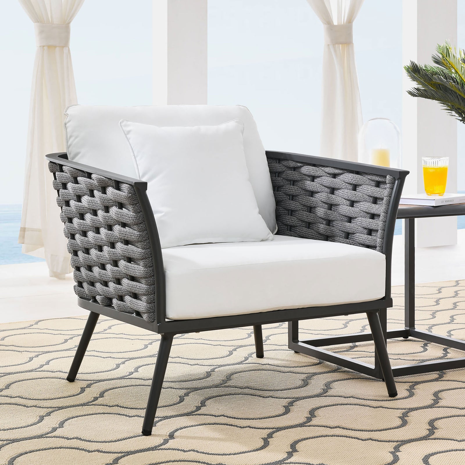 Stance outdoor armchair with white cushions and rope sides arranged beside a patio table || EEI-3054-GRY-WHI || front_angle_room
