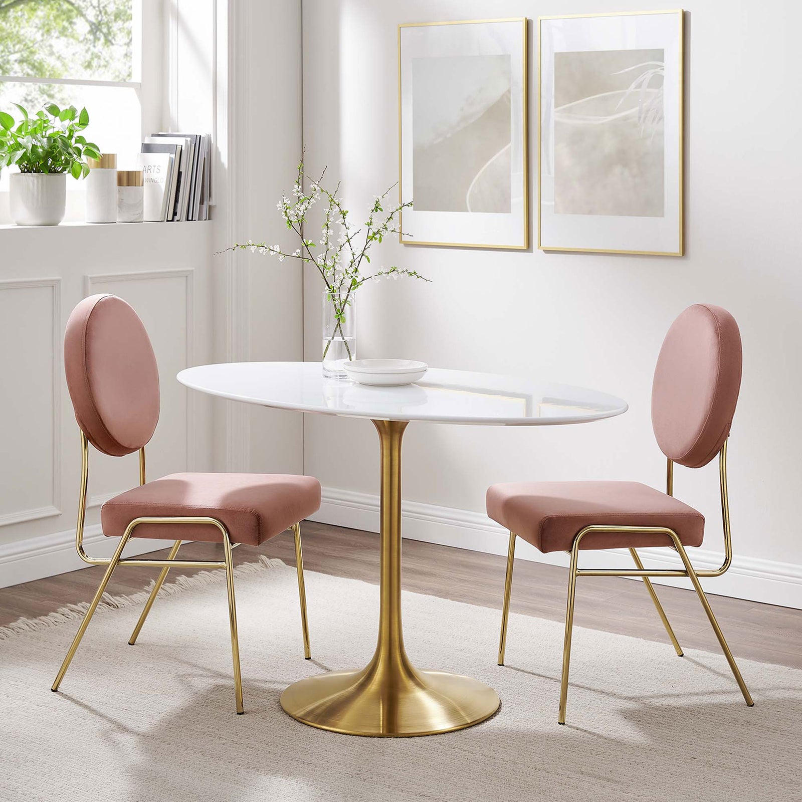 White oval pedestal dining table with gold base styled with blush chairs in a bright modern nook. || EEI-3215-GLD-WHI || front_room