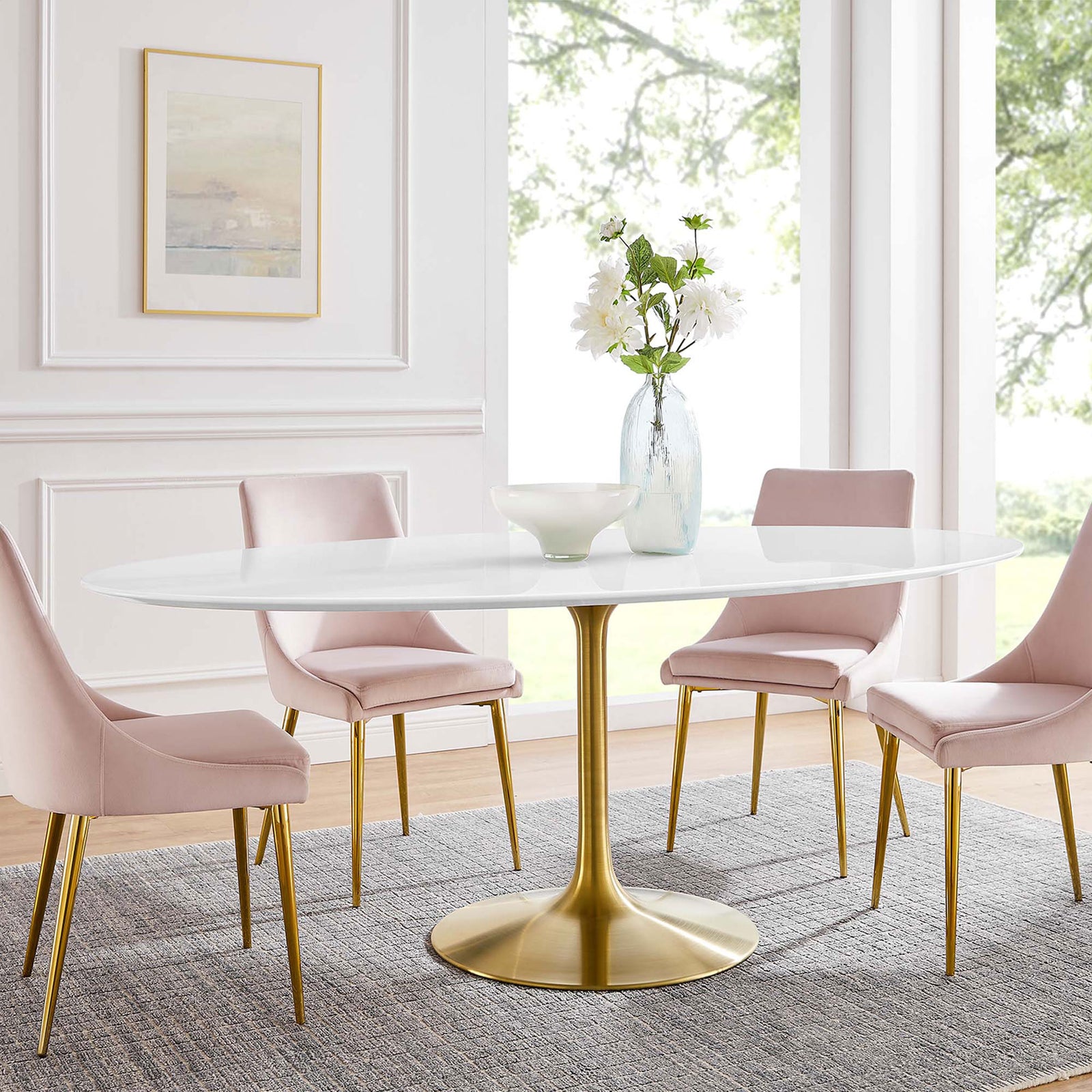 Large white oval pedestal dining table with gold base styled with blush chairs in an airy dining room. || EEI-3255-GLD-WHI || front_room