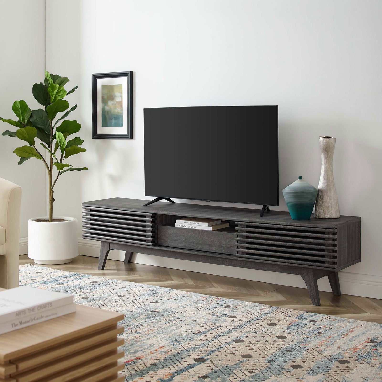 Charcoal TV stand styled in a modern living room with TV, rug, and decor accents || EEI-3305-CHA || front_angle_room