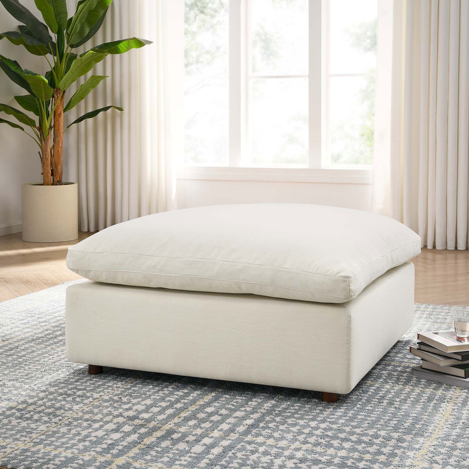 Light beige overstuffed ottoman styled in a bright living room, inviting you to stretch out and unwind. || EEI-3318-LBG || front_angle_room
