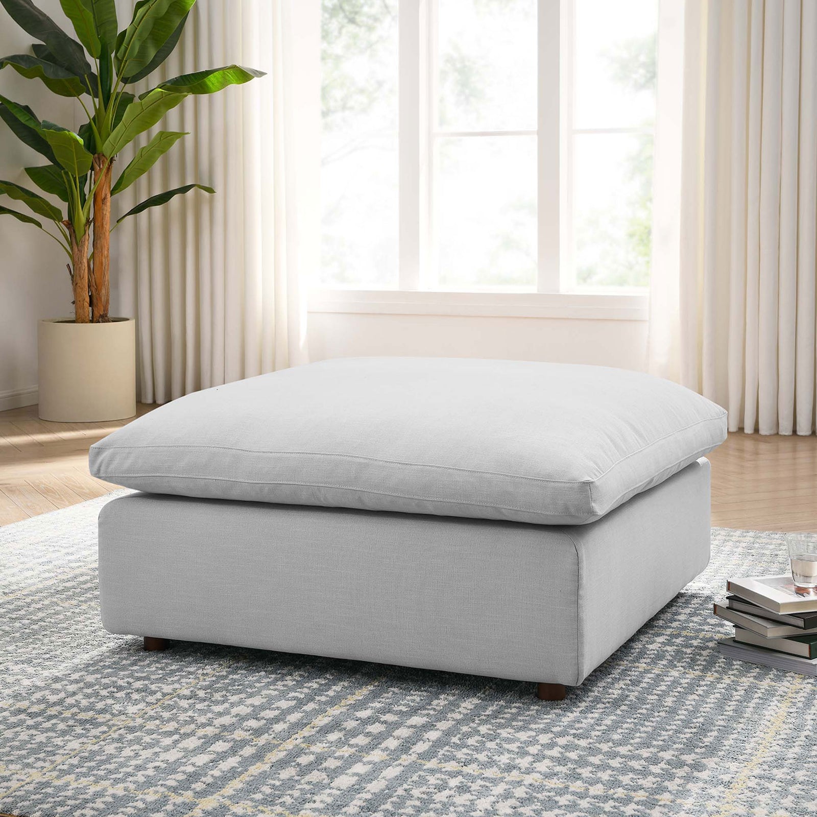 Light gray ottoman anchors a bright living room with its oversized cushion and inviting modern profile. || EEI-3318-LGR || front_angle_room