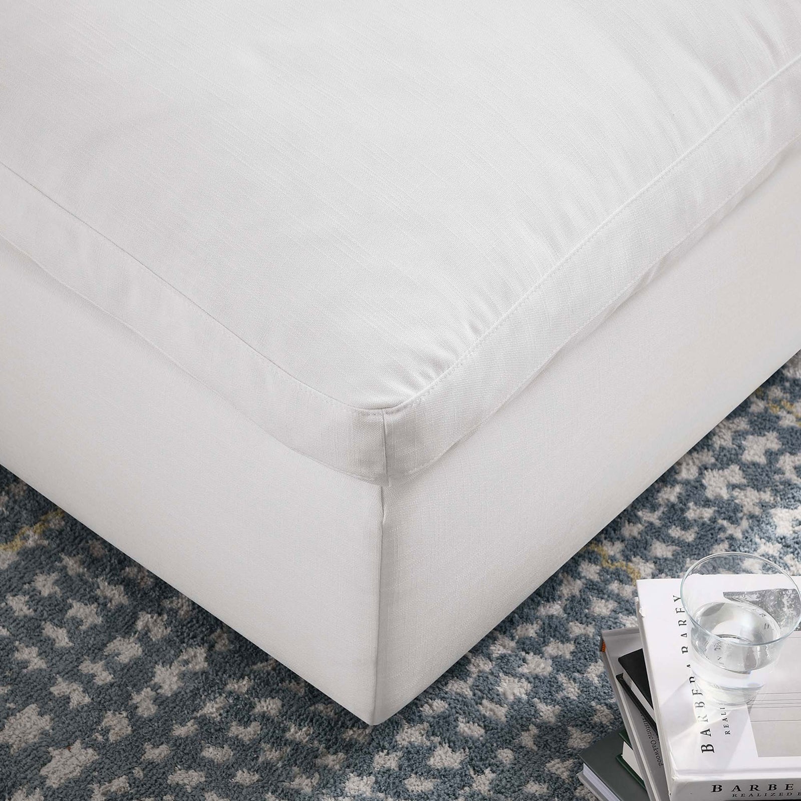 Commix ottoman corner highlighting the tailored piping, linen-textured pure white fabric, and cozy living room setting || EEI-3318-PUW || detail_room