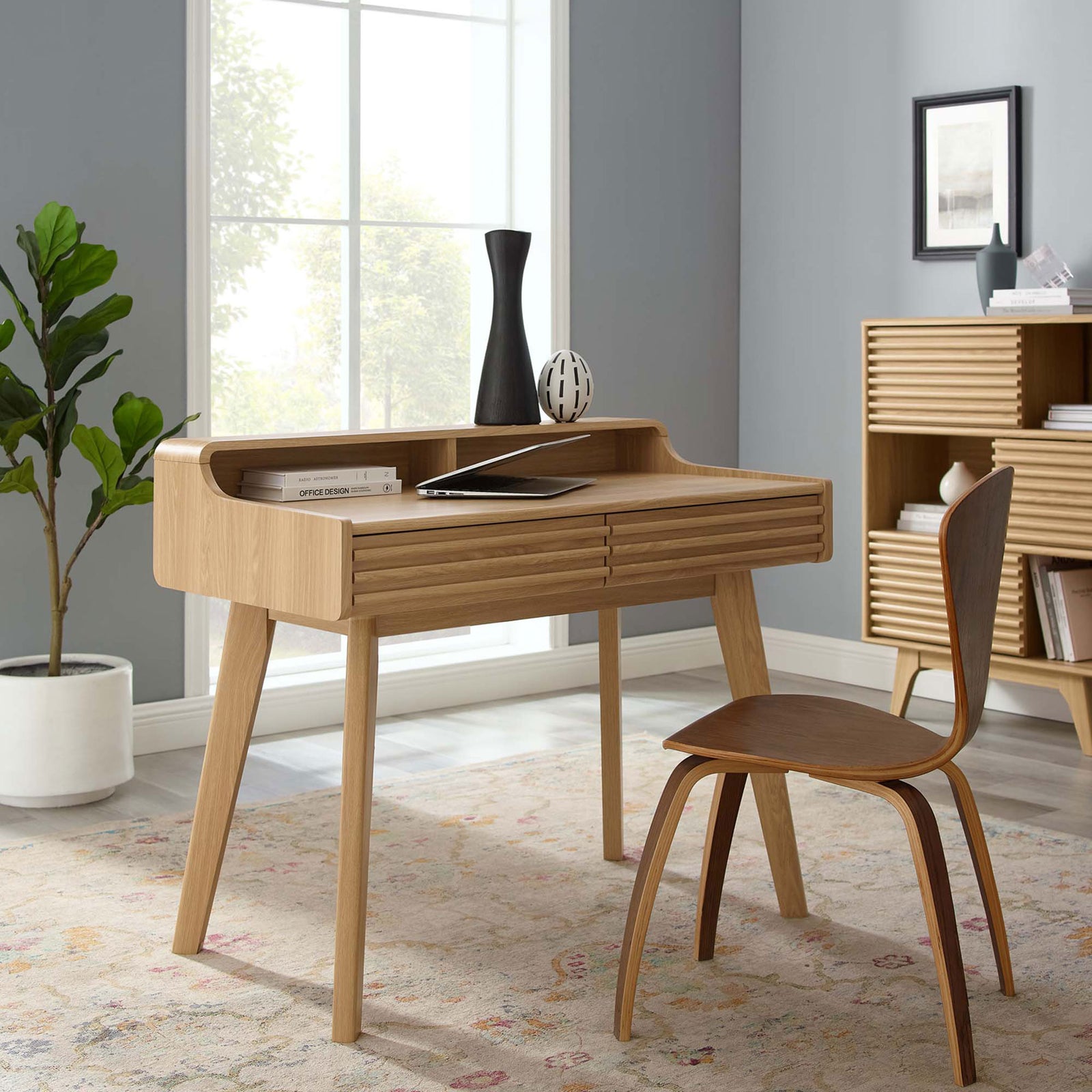Sleek oak writing desk elevates modern decor with louvered fronts and airy tapered legs || EEI-3342-OAK || front_angle_room