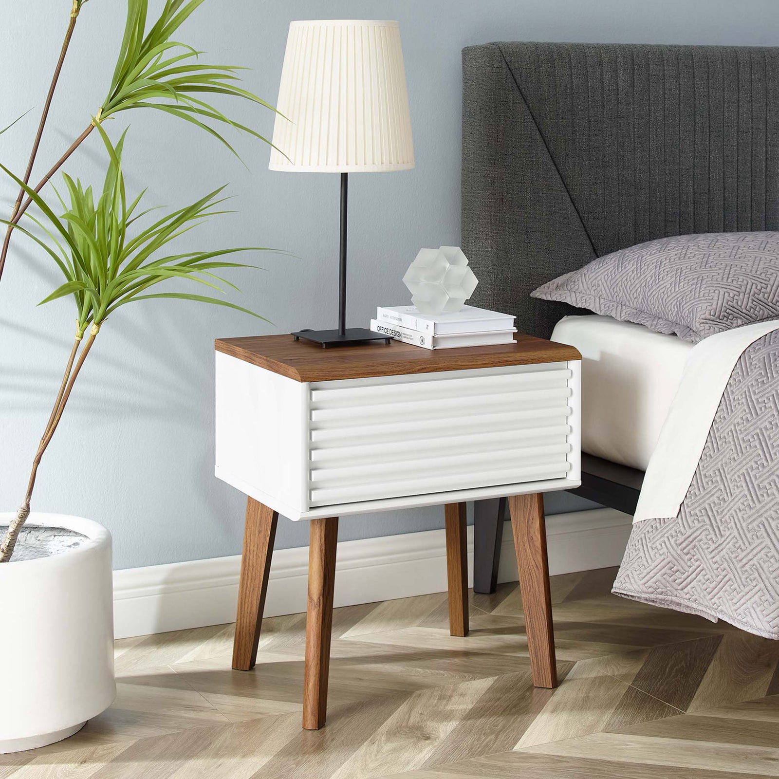 Render end table styled beside a bed, showcasing walnut top surface and sculpted tapered legs || EEI-3345-WAL-WHI || front_angle_room