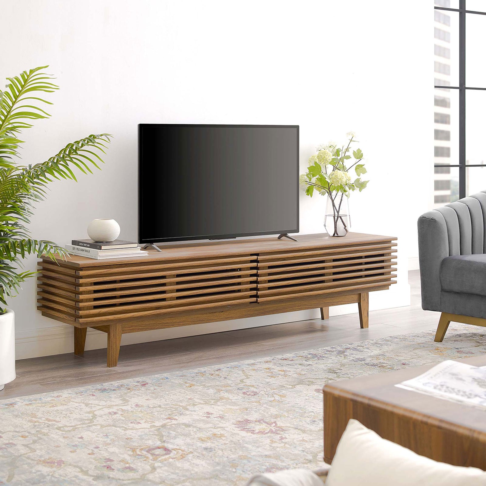 Walnut TV stand in a bright living room with TV and contemporary furnishings. || EEI-3348-WAL || front_angle_room