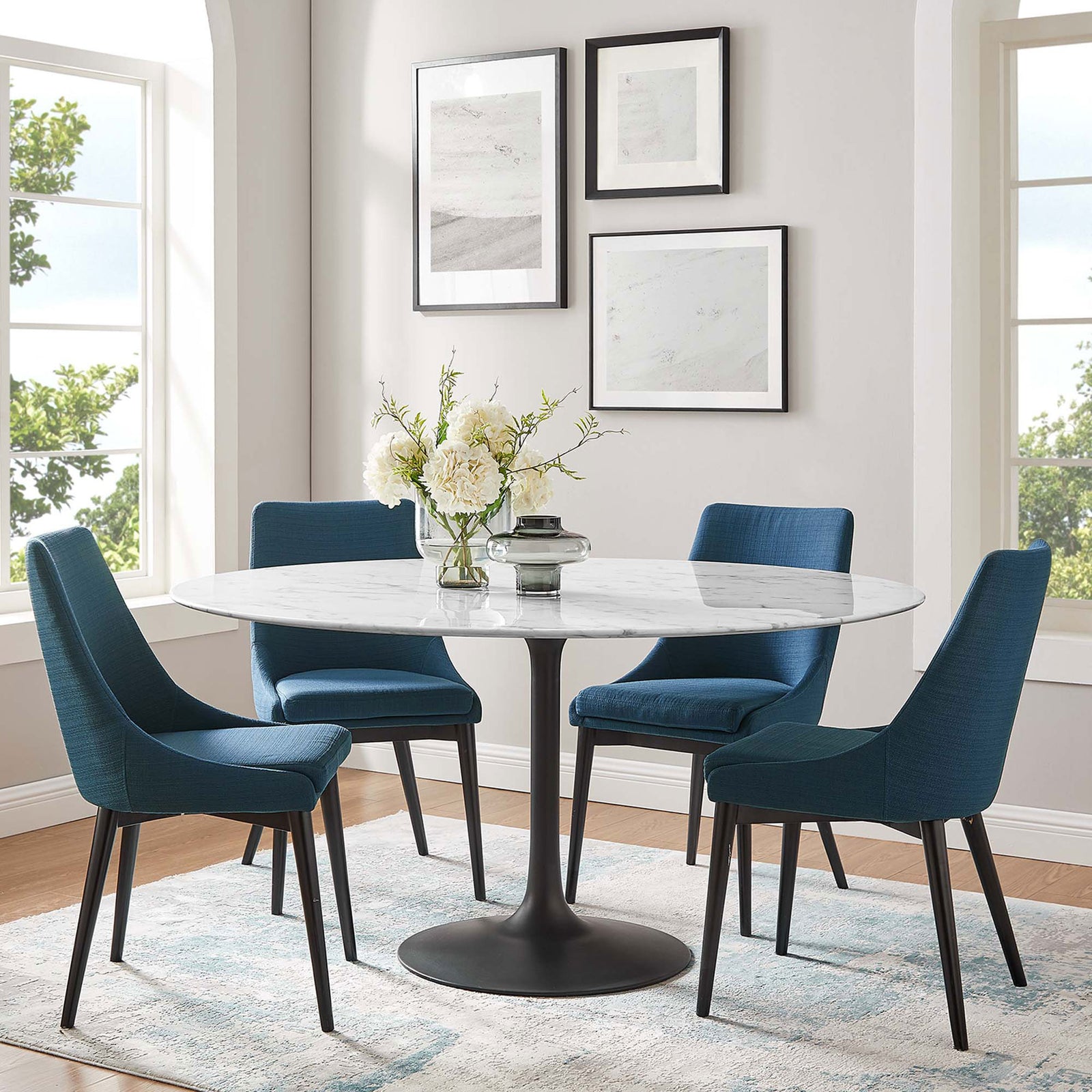 60 inch round faux marble dining table with four blue chairs and flowers in a bright windowed room || EEI-3529-BLK-WHI || front_angle_room