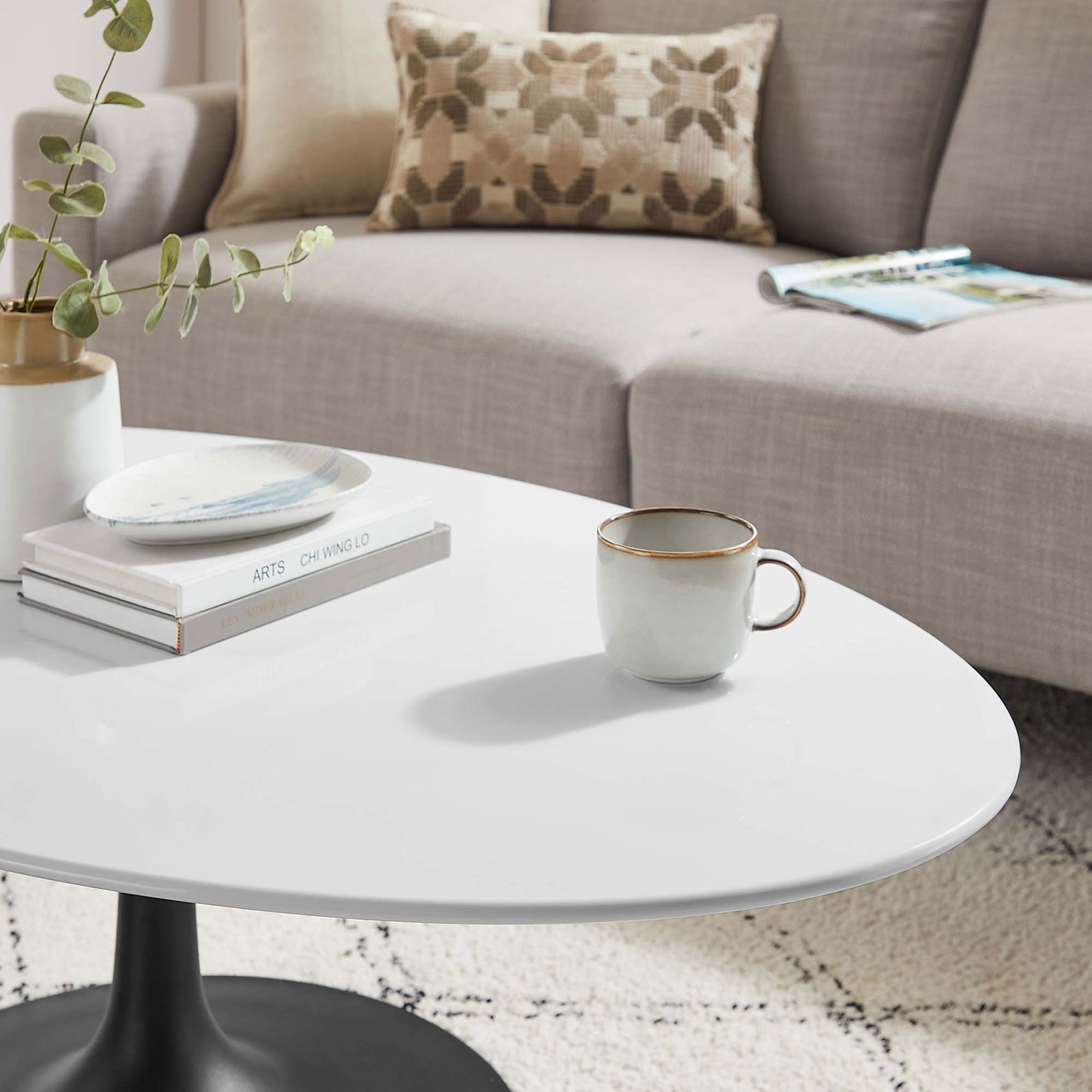 Polished white surface styled with a mug and books in a soft, textured setting. || EEI-3536-BLK-WHI || detail_room