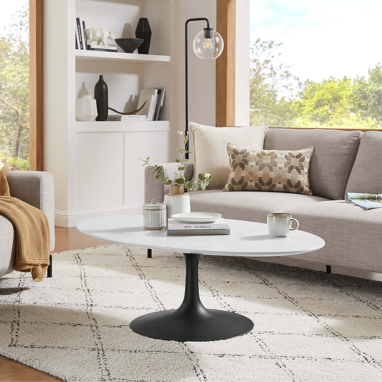 Elegant oval coffee table completes a warm, modern living space. || EEI-3536-BLK-WHI || front_angle_room