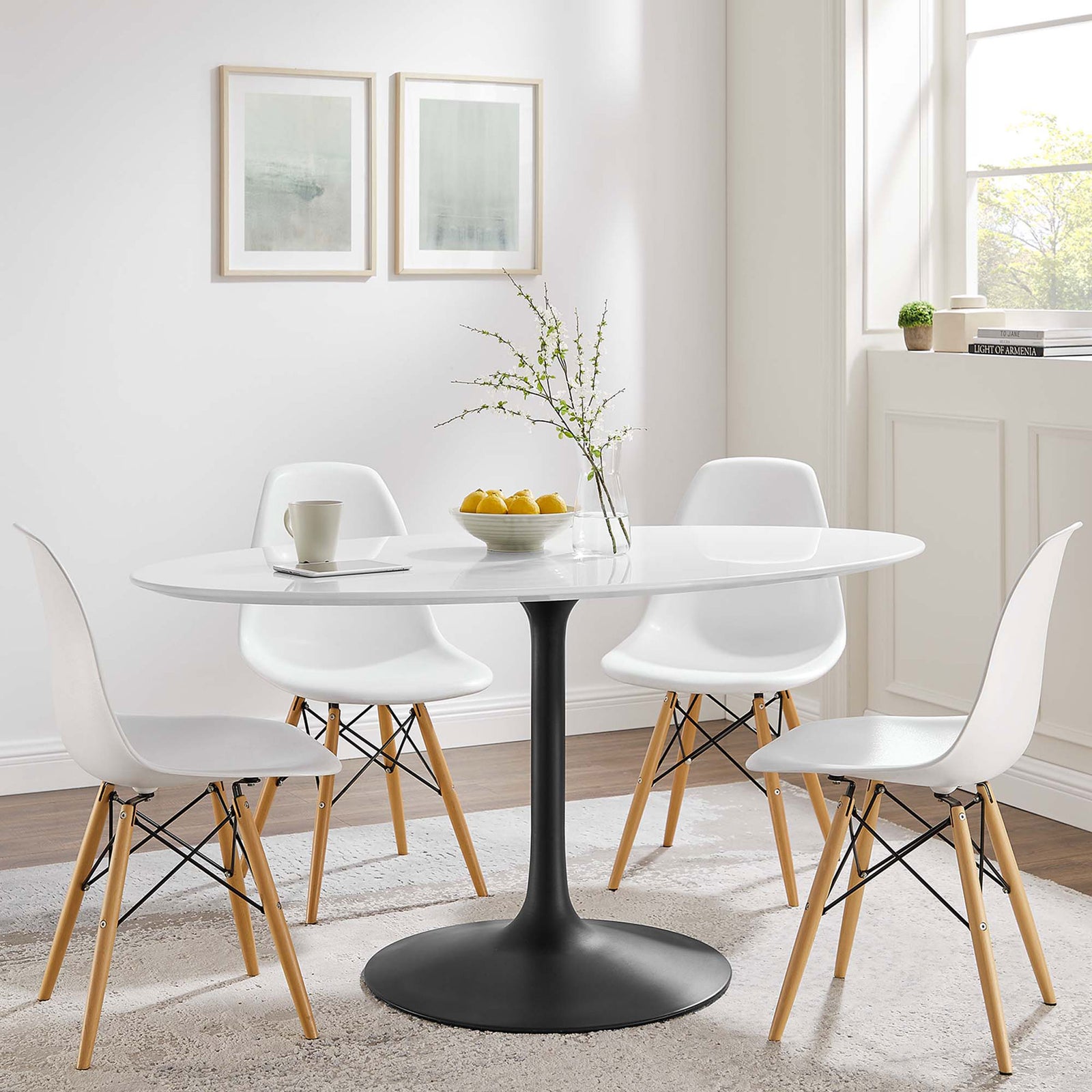 White oval pedestal dining table with black base paired with four modern chairs in a bright dining room || EEI-3539-BLK-WHI || front_angle_room