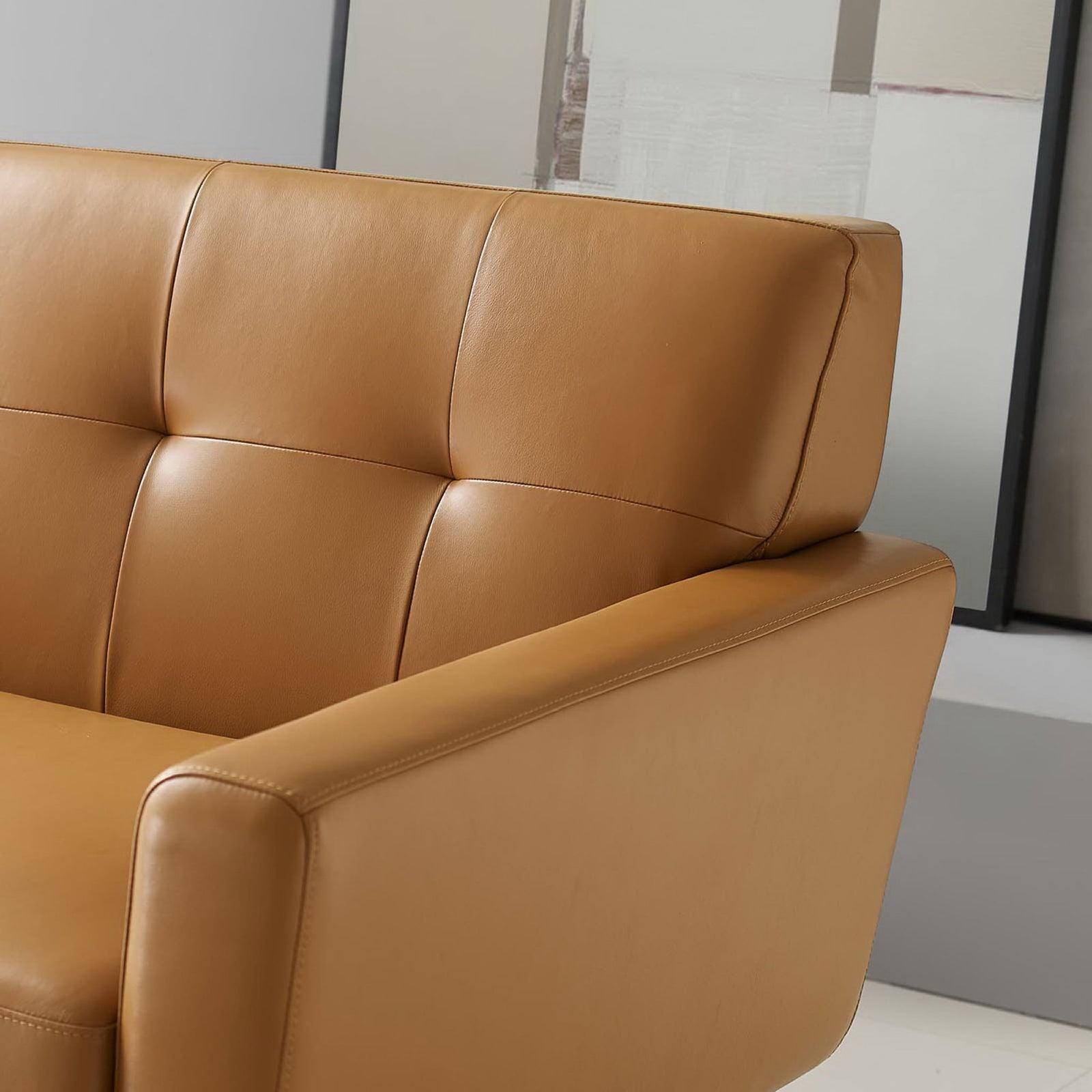 Tufted tan leather backrest and cushioned arm of the Engage mid-century sofa || EEI-3733-TAN || detail_room