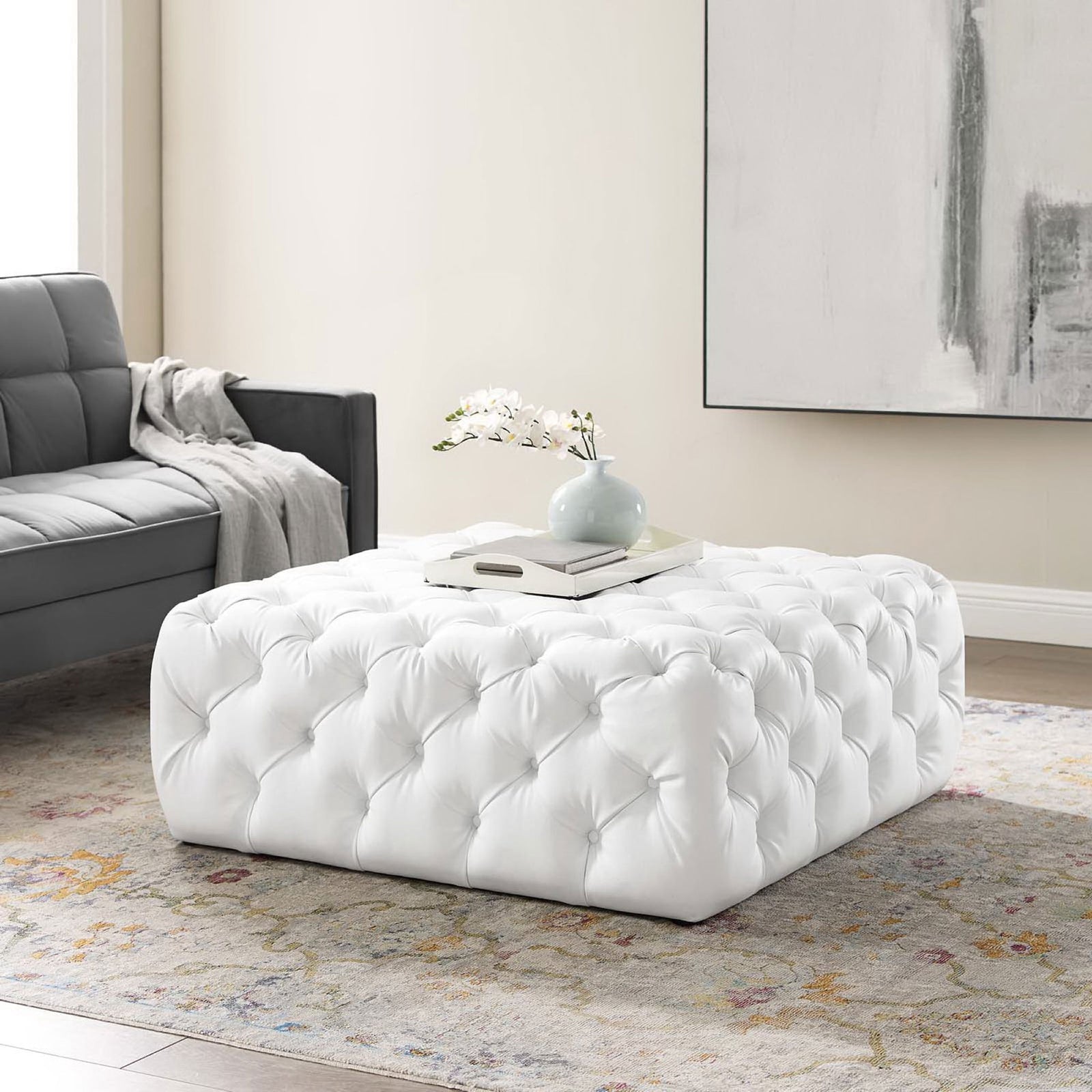 White tufted square ottoman styled as a chic coffee table in a modern living room || EEI-3773-WHI || front_angle_room