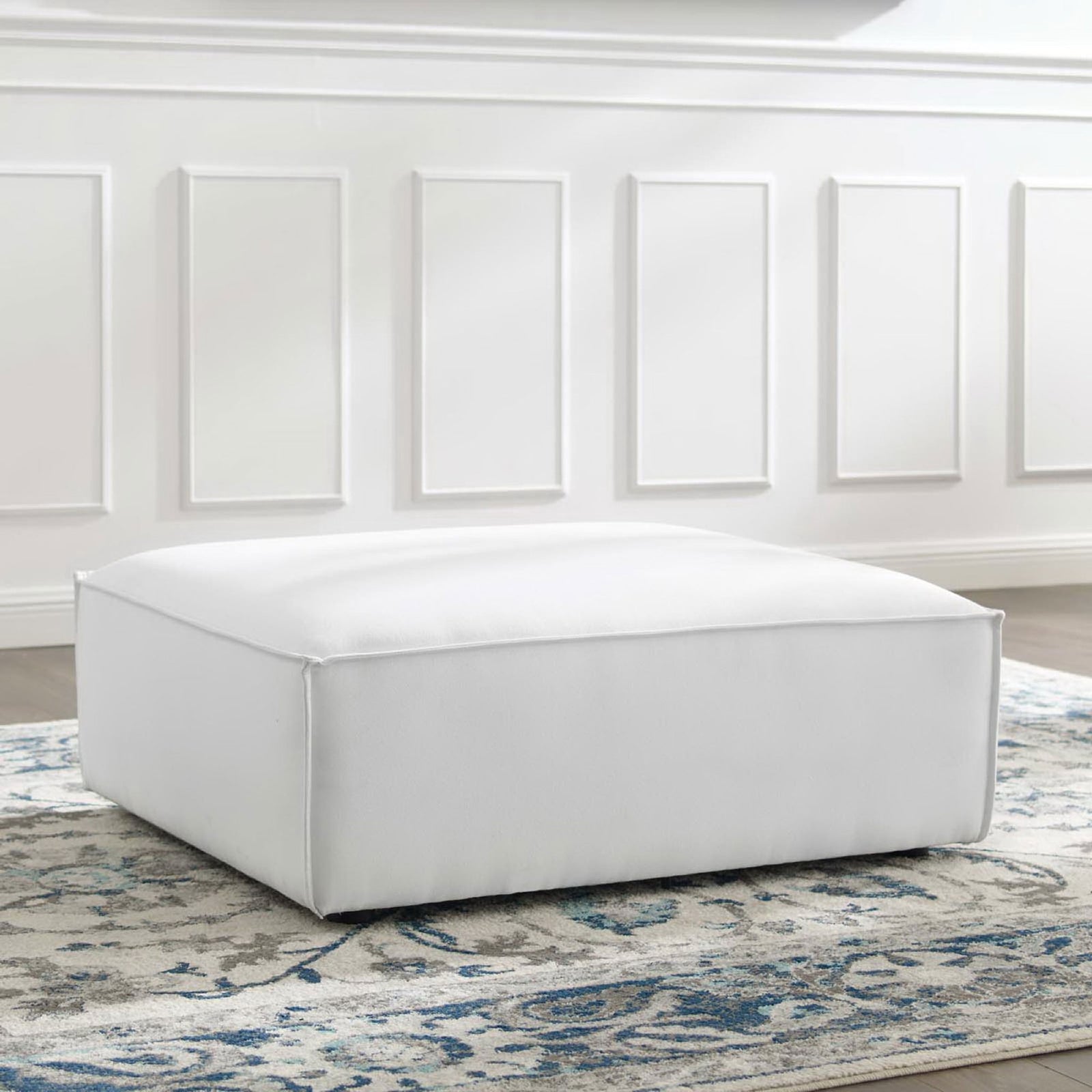 White Restore ottoman on a blue and gray patterned rug adding soft modern comfort to the living room || EEI-3873-WHI || front_angle_room