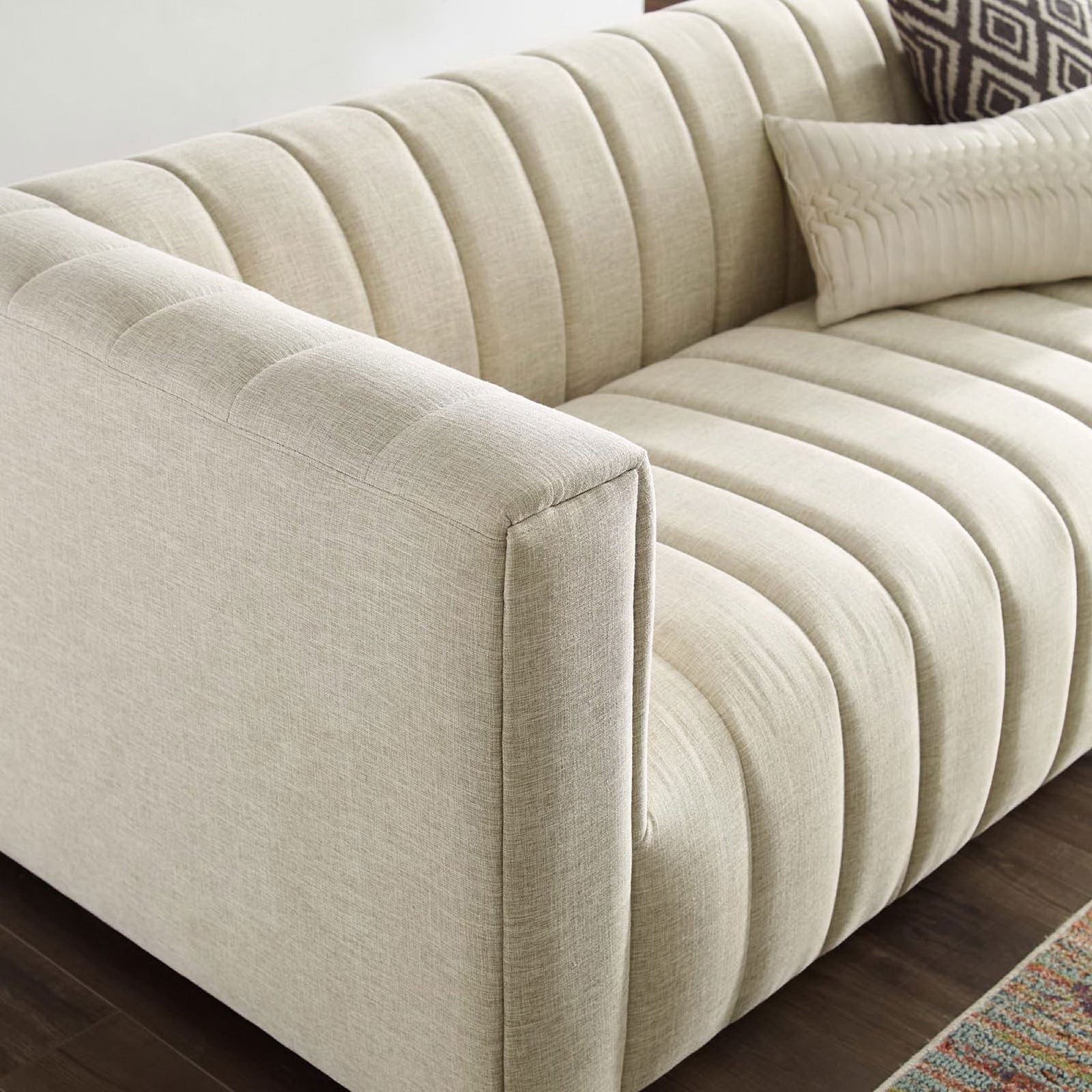 Channel tufted seat and arm in a styled living room with soft beige upholstery and accent pillows || EEI-3881-BEI || detail_room
