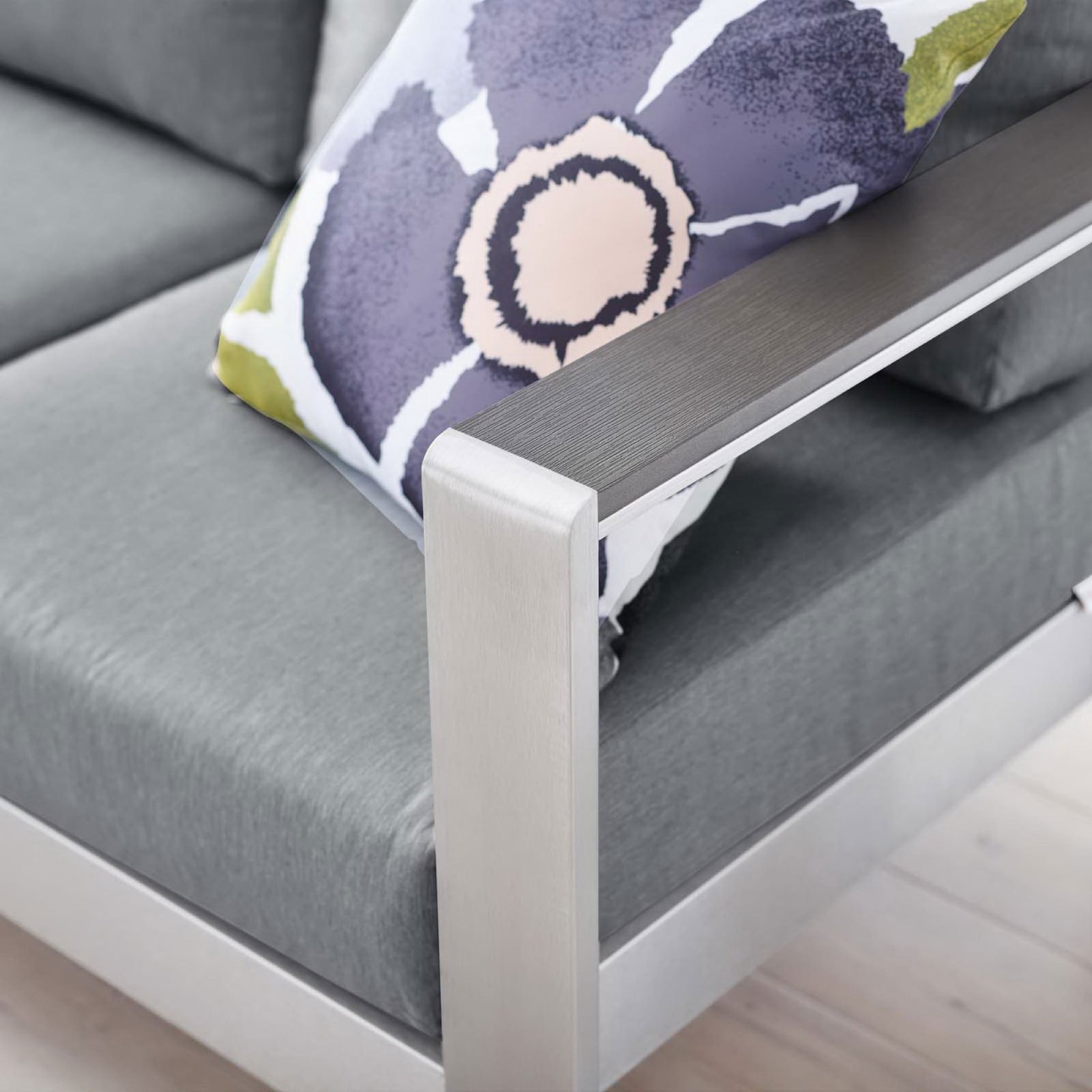 Brushed aluminum armrest pairs with smooth gray cushions and a bold floral accent pillow || EEI-3917-SLV-GRY || detail_room