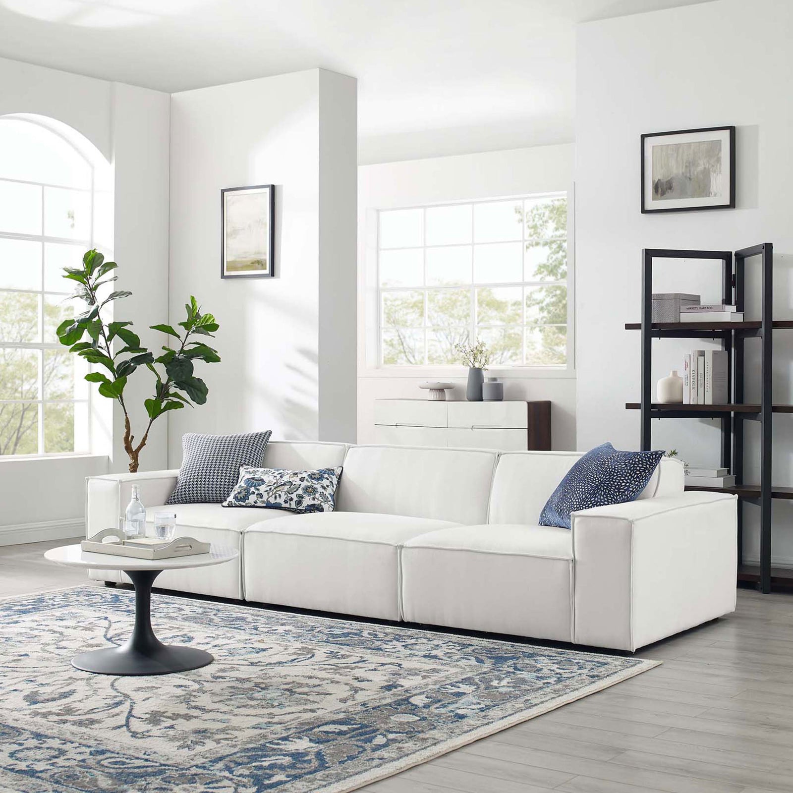 White Restore sectional sofa arranged in a bright living room with rug, coffee table, and decor accents. || EEI-4112-WHI || front_angle_room