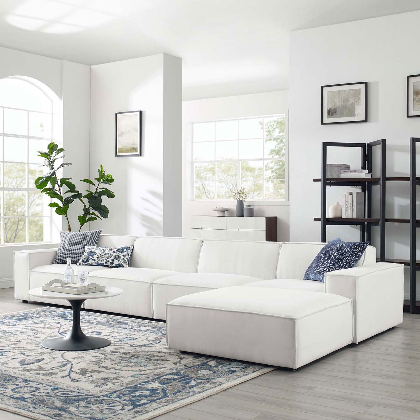 White Restore sectional arranged in a modern living room with rug, coffee table, and decor accents || EEI-4115-WHI || front_angle_room