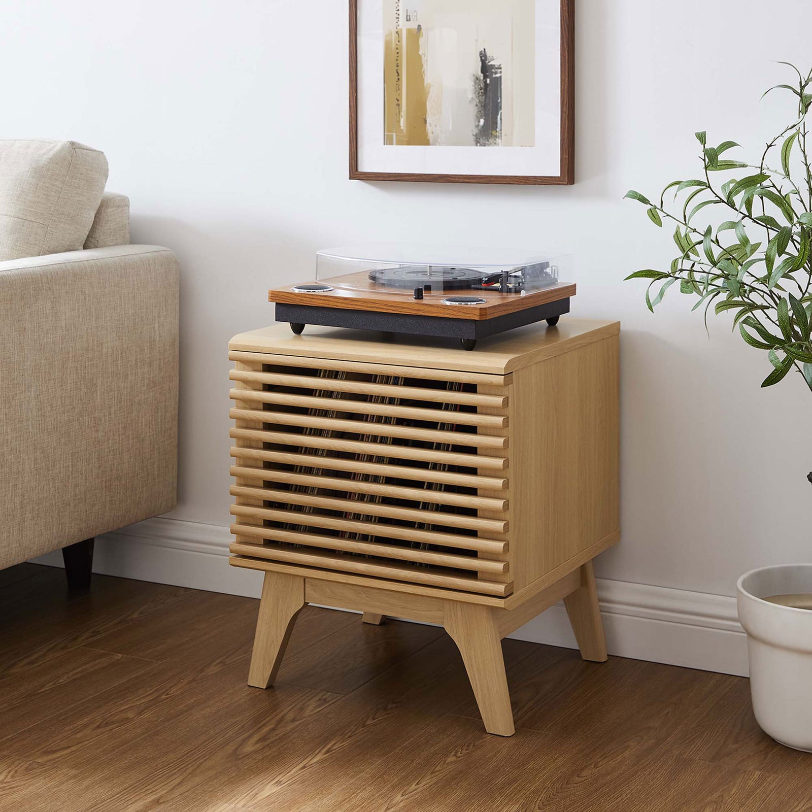 Oak vinyl record stand with turntable styled beside a sofa, artwork, and greenery || EEI-4262-OAK || front_angle_room