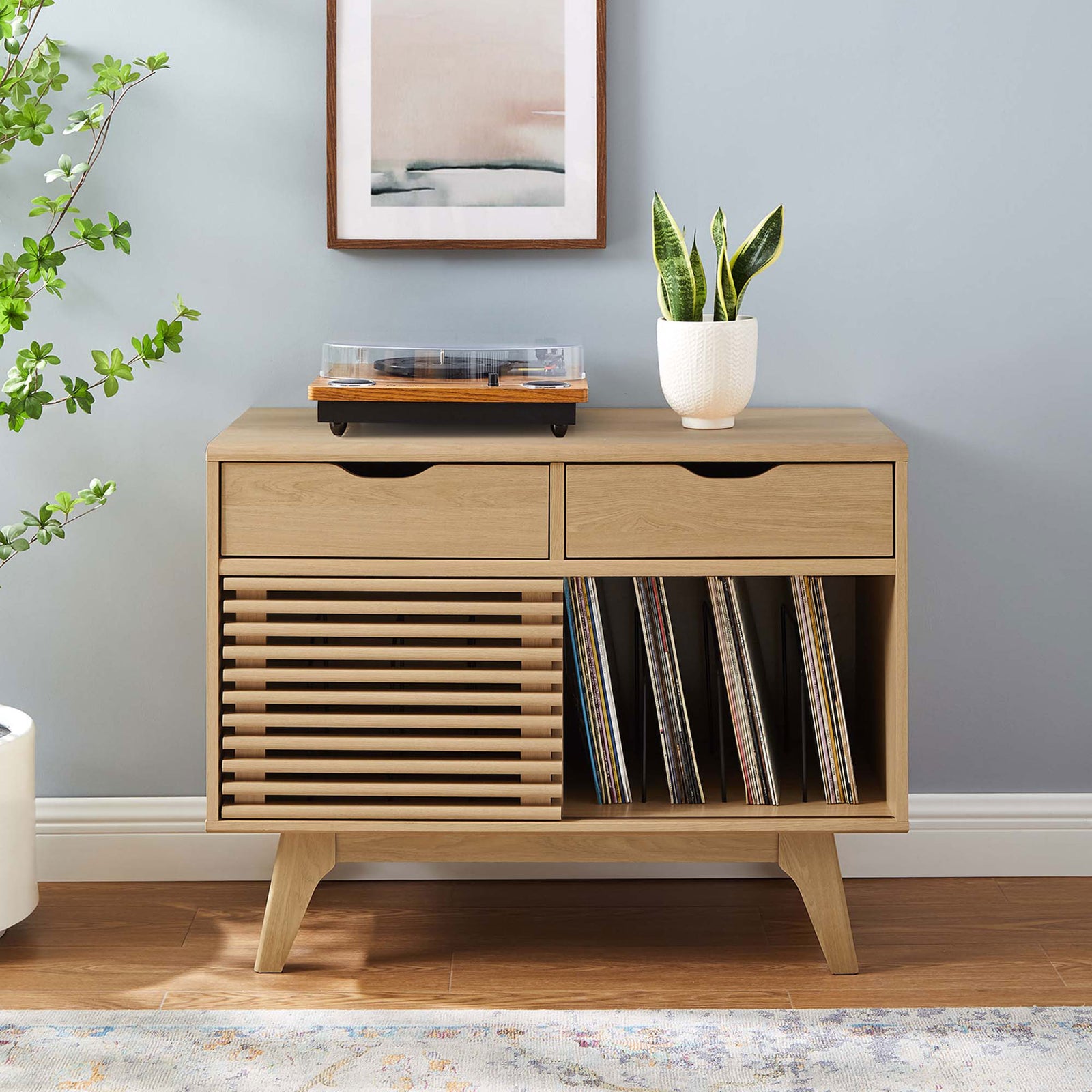 Oak vinyl record stand centered in a cozy living room with art, greenery, and ample storage for albums and media || EEI-4323-OAK || front_room