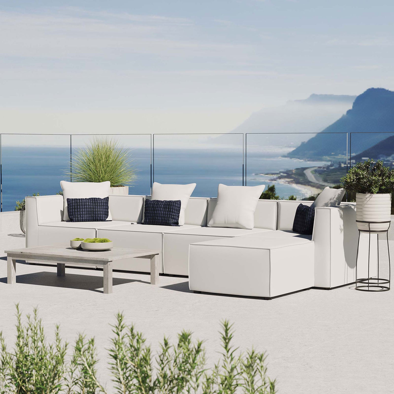 White Saybrook outdoor sectional styled on a bright coastal patio with greenery || EEI-4382-WHI || front_angle_room