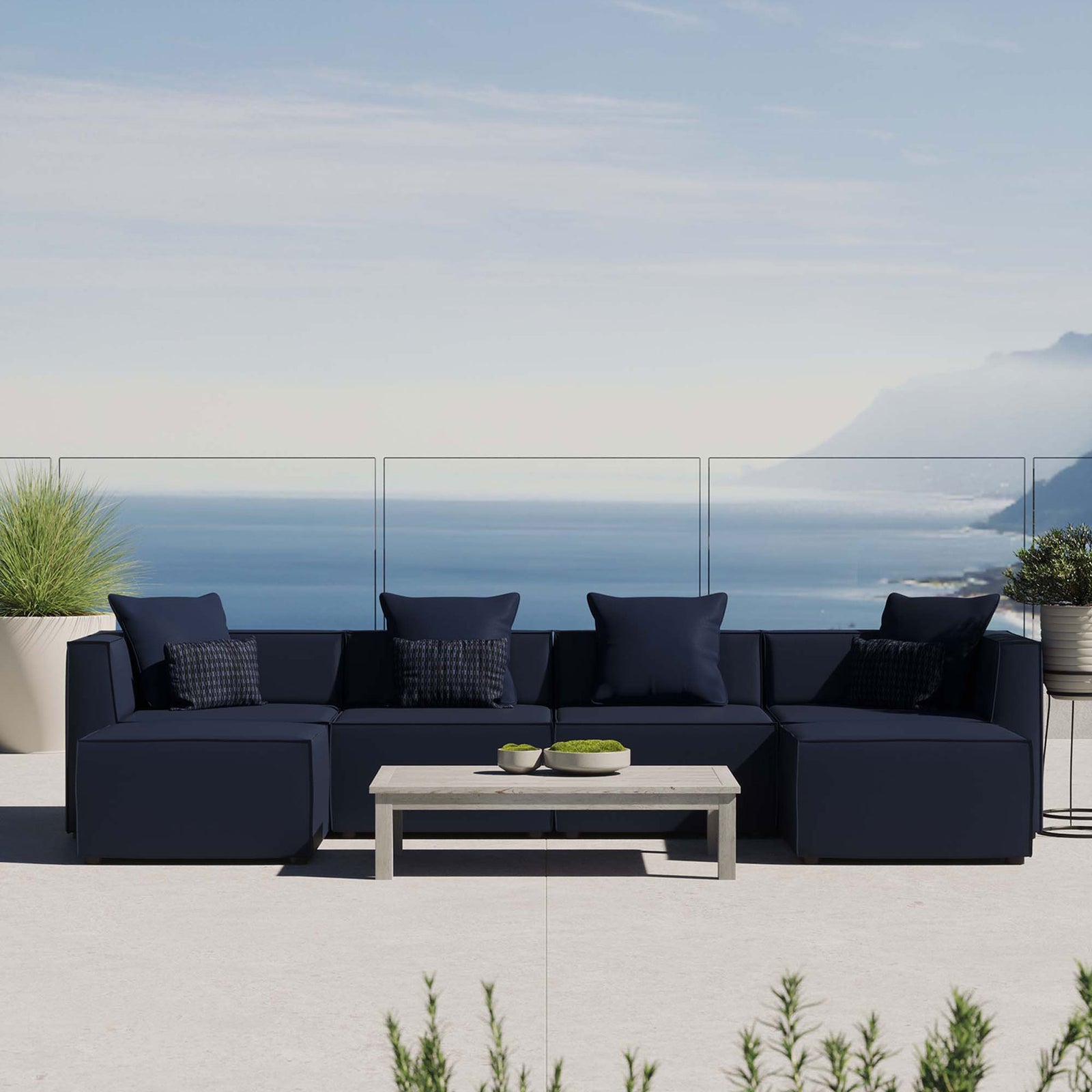 Navy Saybrook outdoor sectional styled on a coastal patio with accent pillows and a modern coffee table. || EEI-4383-NAV || front_room