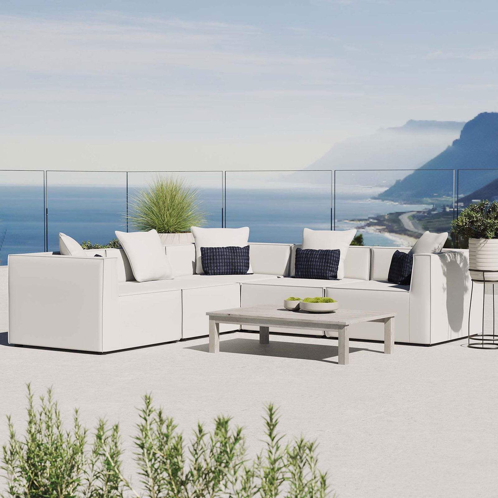 White Saybrook sectional styled on a rooftop patio with coastal view and low profile coffee table || EEI-4384-WHI || front_angle_room